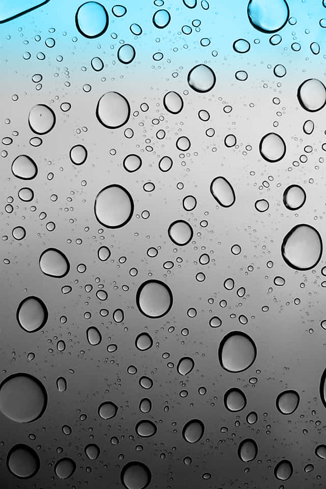 iOS 4 桌布 壁紙 — 雨滴依附在玻璃表面，展現出從藍色到灰色的漸變天空。