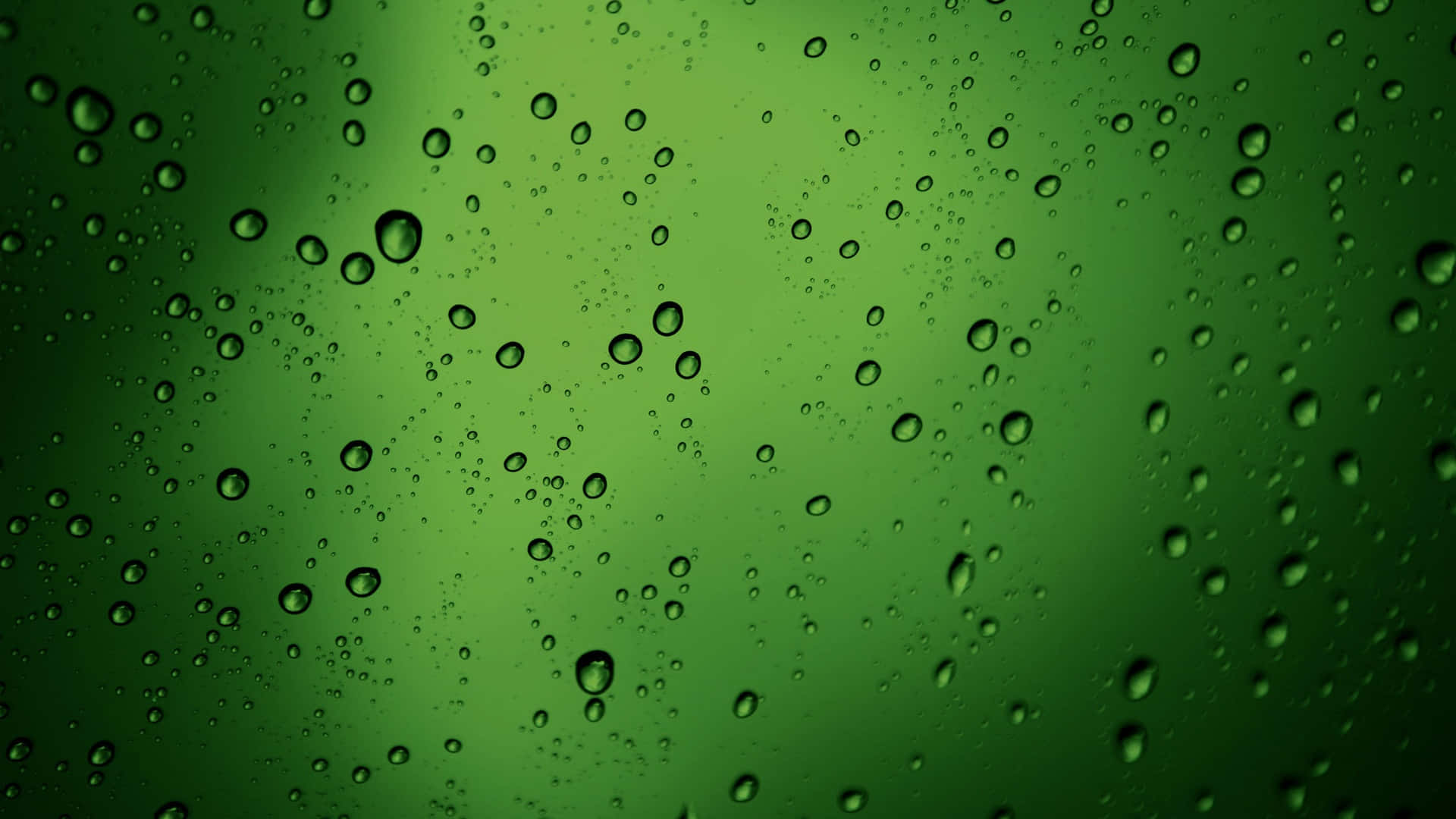 綠色 桌布 壁紙 — 雨滴依附在玻璃表面，顯露出帶有柔和光線反射的綠色漸變背景。