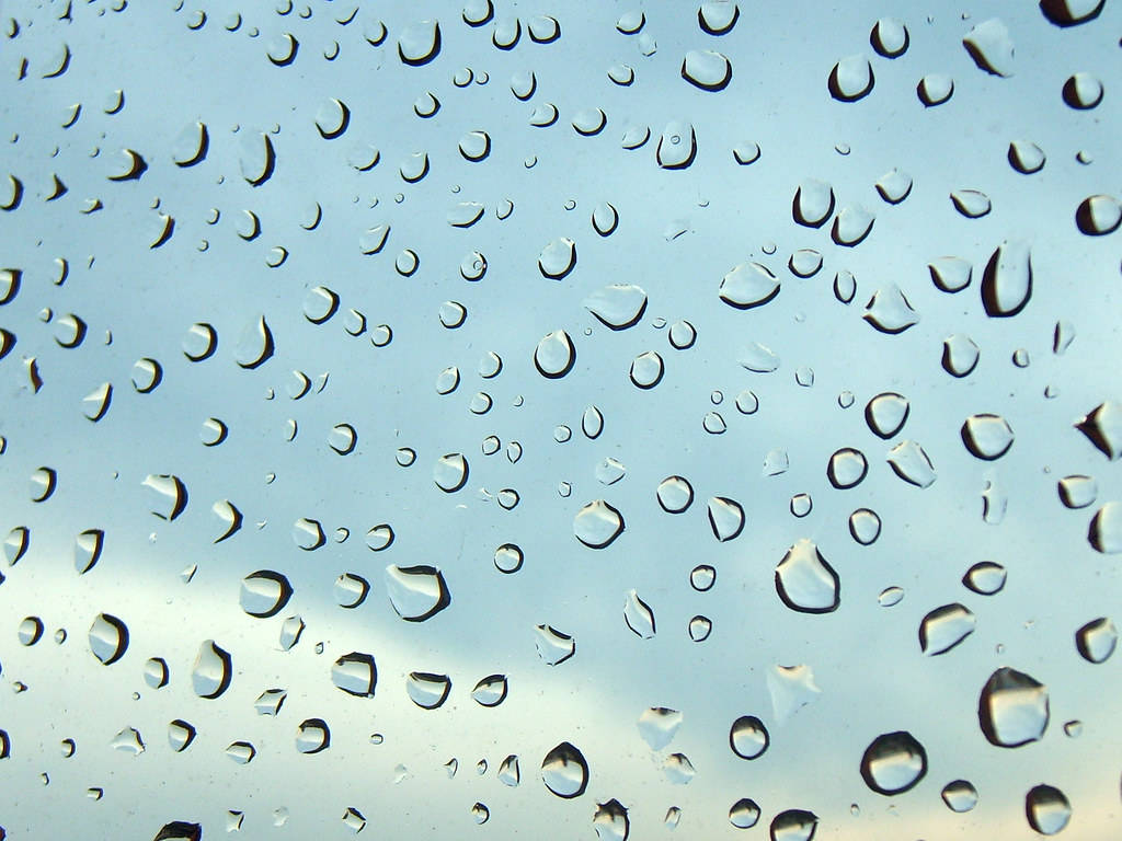 Rainy Day 桌布 壁紙 — 雨滴依附在玻璃表面，顯露出柔和的藍天和微妙的雲影。