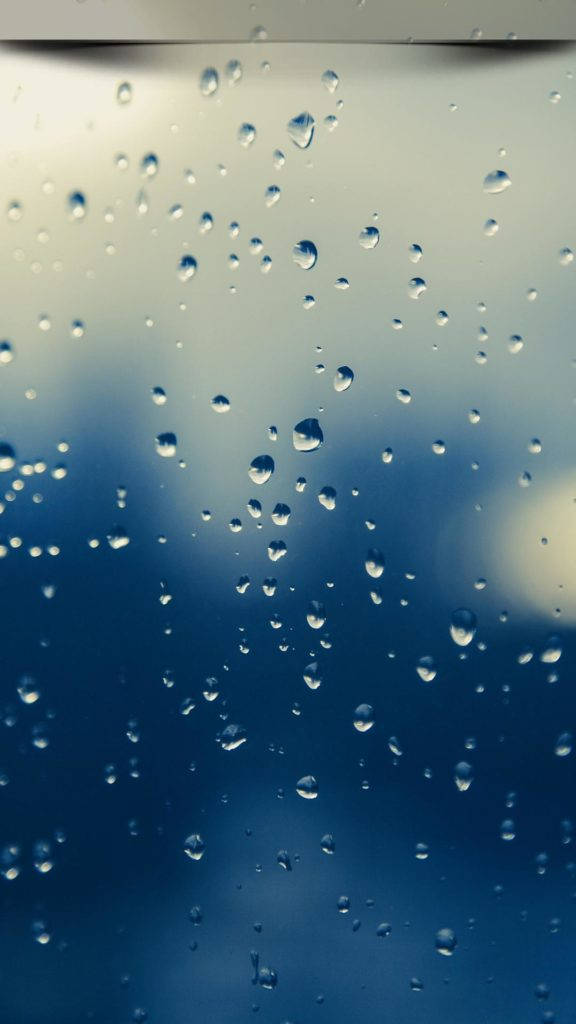 安卓手機 桌布 壁紙 — 雨滴依附在玻璃表面，顯露出模糊的藍天和柔軟的雲朵。
