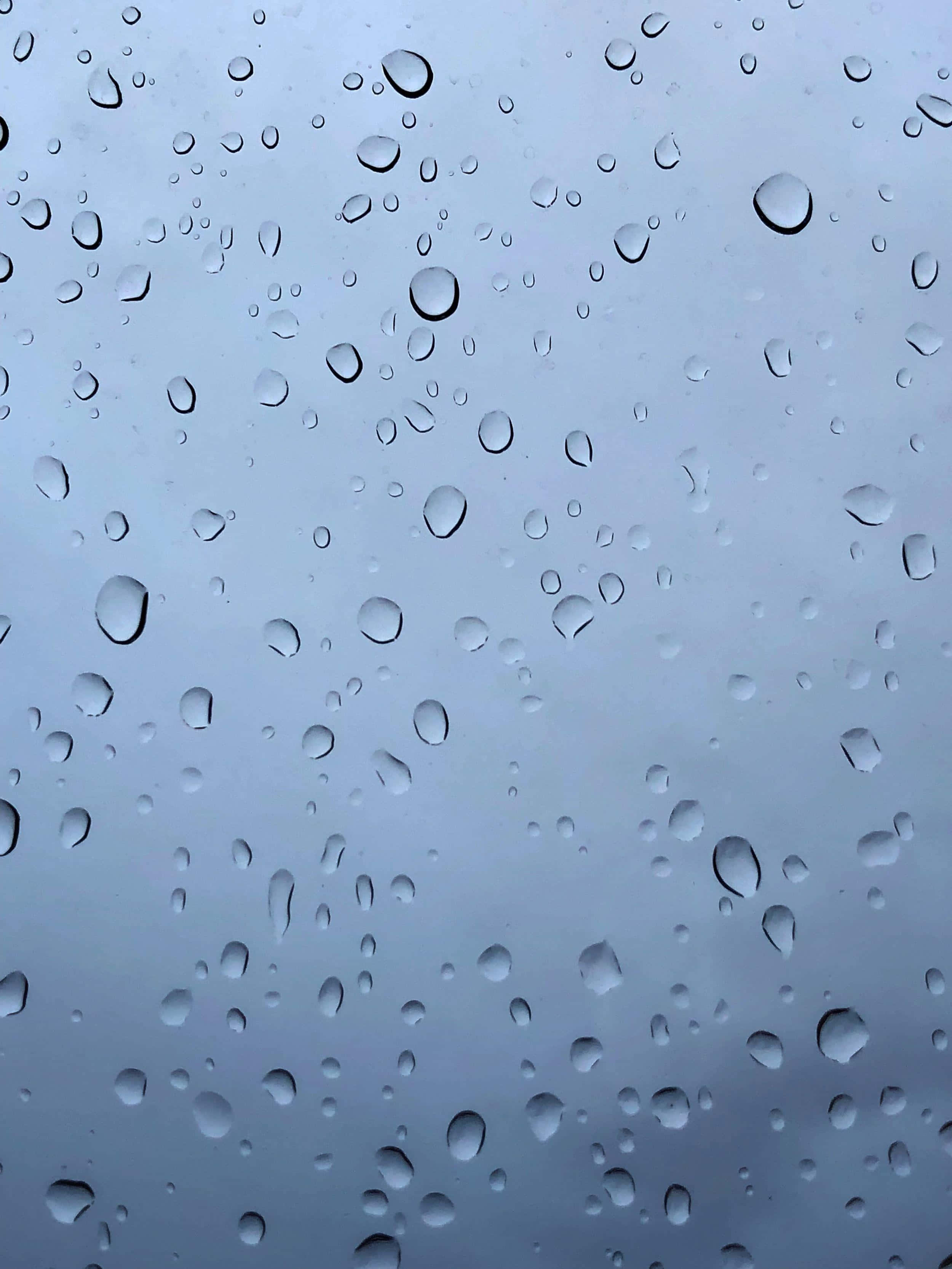 Water Droplet 桌布 壁紙 — 雨滴依附在玻璃表面，顯露出背後柔和的灰色天空。