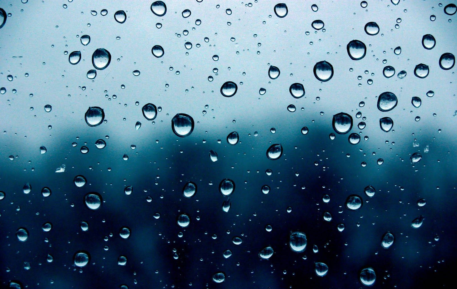 Rainy Day 桌布 壁紙 — 雨滴依附在玻璃表面，顯露出背後模糊的藍灰色世界。