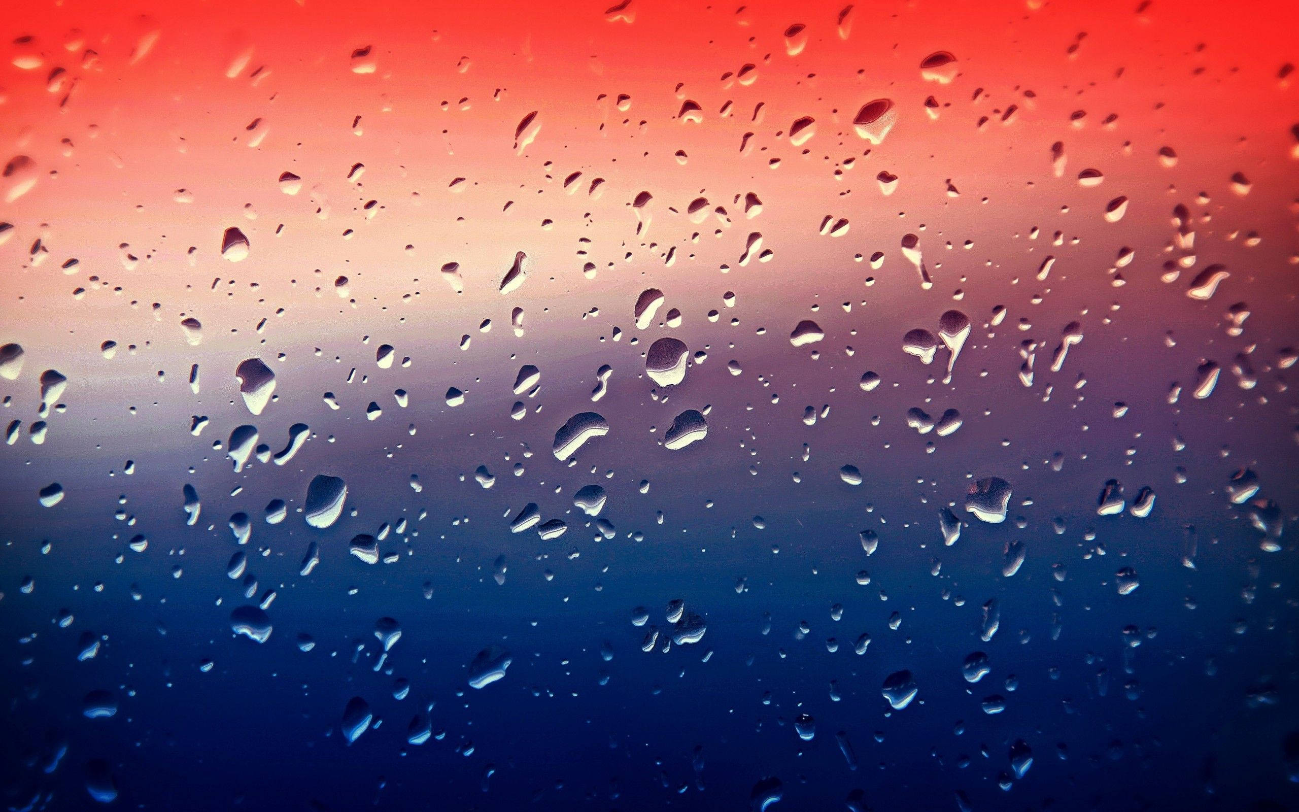 漸層 桌布 壁紙 — 雨滴依附在窗戶上，展現出從火紅到深藍的鮮豔漸變天空。