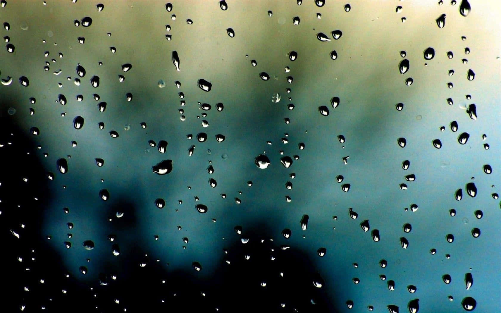 Rain Drops 桌布 壁紙 — 雨滴依附在窗戶上，露出背後模糊的藍綠色天空。