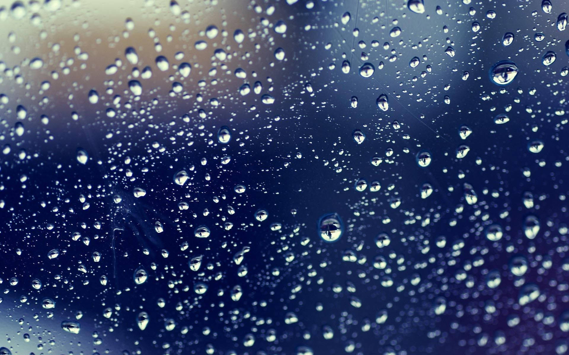 Rainy Day 桌布 壁紙 — 雨滴依附在窗戶上，顯露出模糊的藍色和黃色背景。