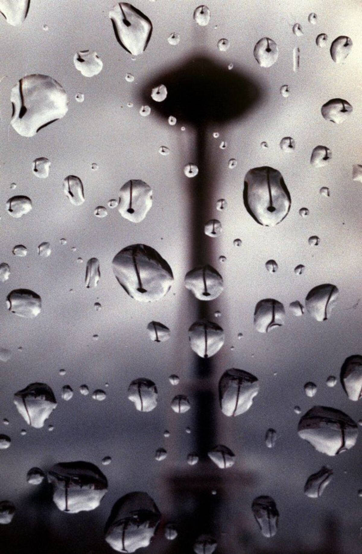 Raindrops 桌布 壁紙 — 雨滴依附在窗戶上，顯露出西雅圖太空針塔在灰色天空下的模糊輪廓。