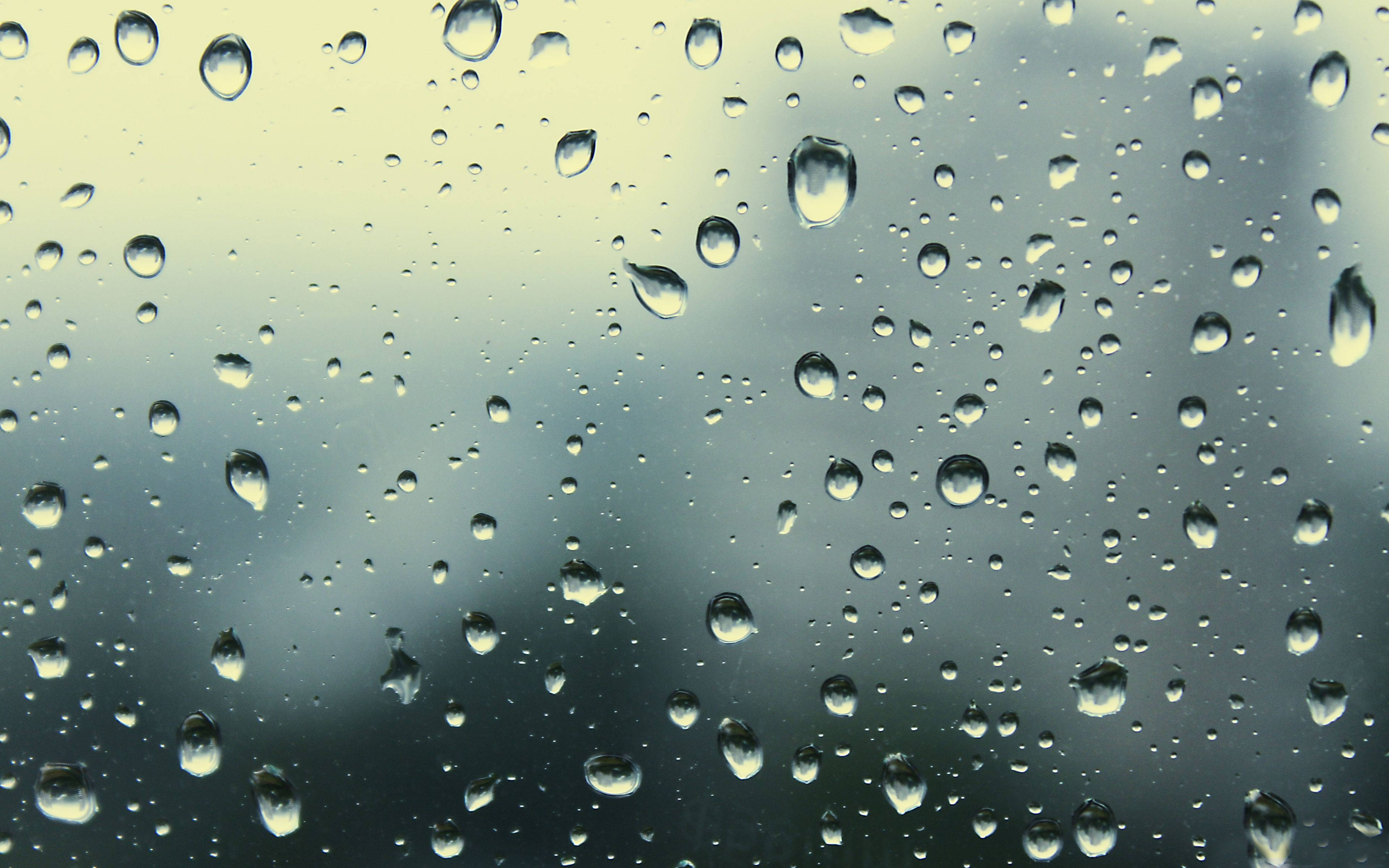Rainy Day 桌布 壁紙 — 雨滴依附在窗玻璃上，模糊了從淡黃色到柔和藍色的柔和漸變天空。
