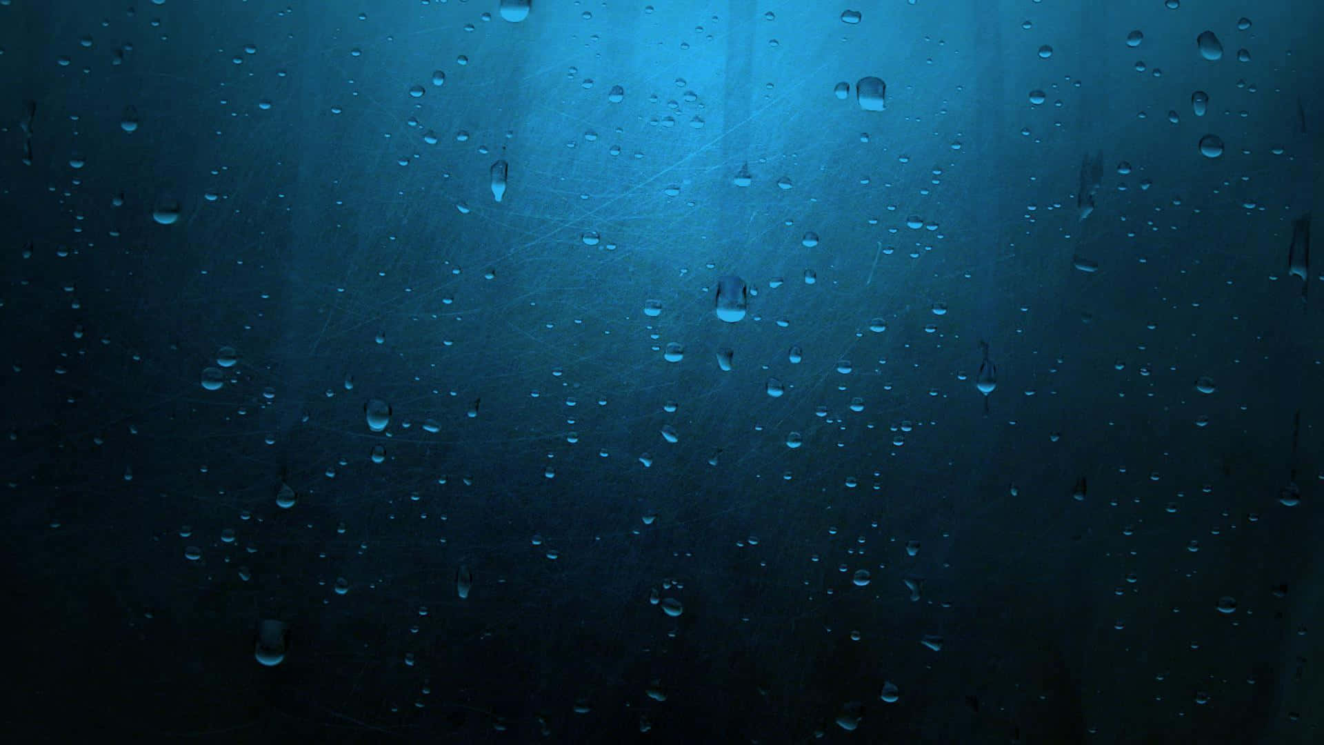 Rain Drops 桌布 壁紙 — 雨滴依附在窗玻璃上，清冷的藍光透過，營造出陰鬱而充滿氛圍的場景。