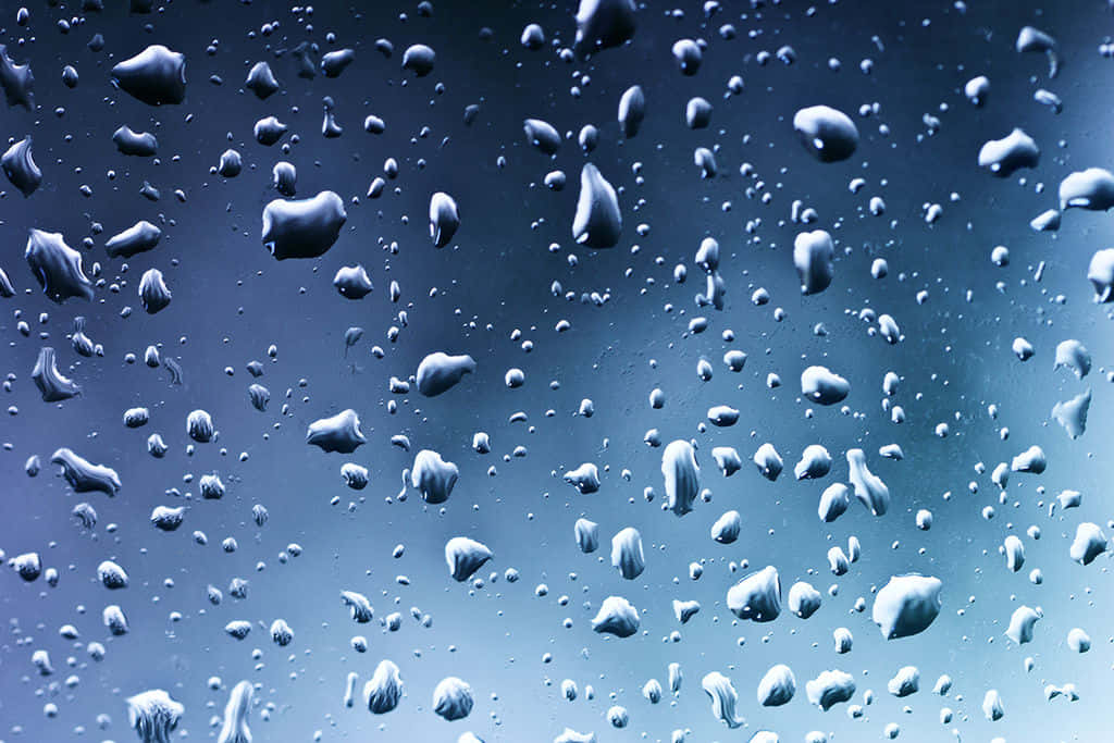 Water Texture 桌布 壁紙 — 雨滴依附在窗玻璃上，背景是清涼的藍色漸變天空。