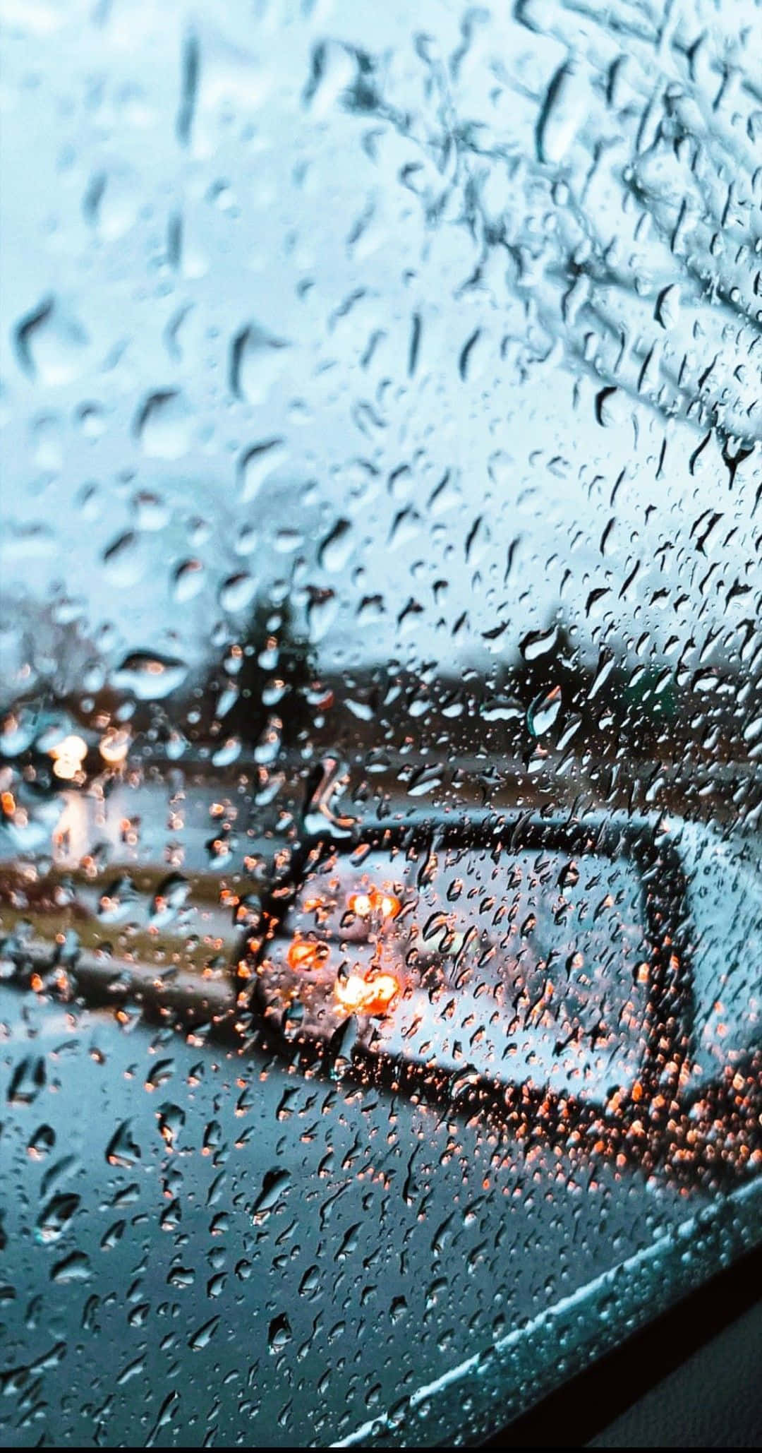 Aesthetic Rain 桌布 壁紙 — 雨滴劃過汽車車窗，模糊的城市燈光溫暖地透過濕玻璃閃爍。