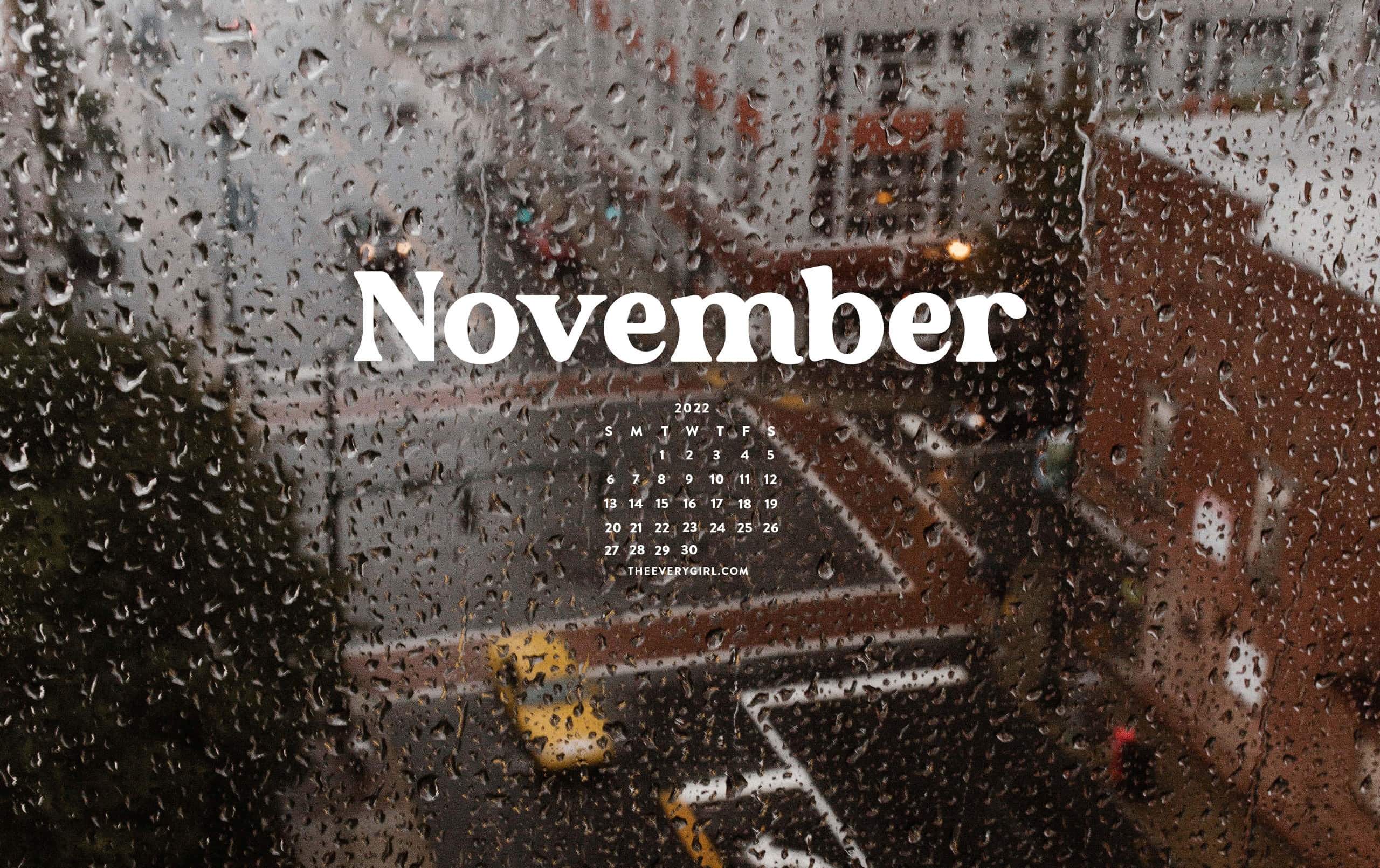 Months 桌布 壁紙 — 雨滴劃過窗戶，窗外是模糊的城市街道，有一輛黃色計程車和十一月日曆文字。