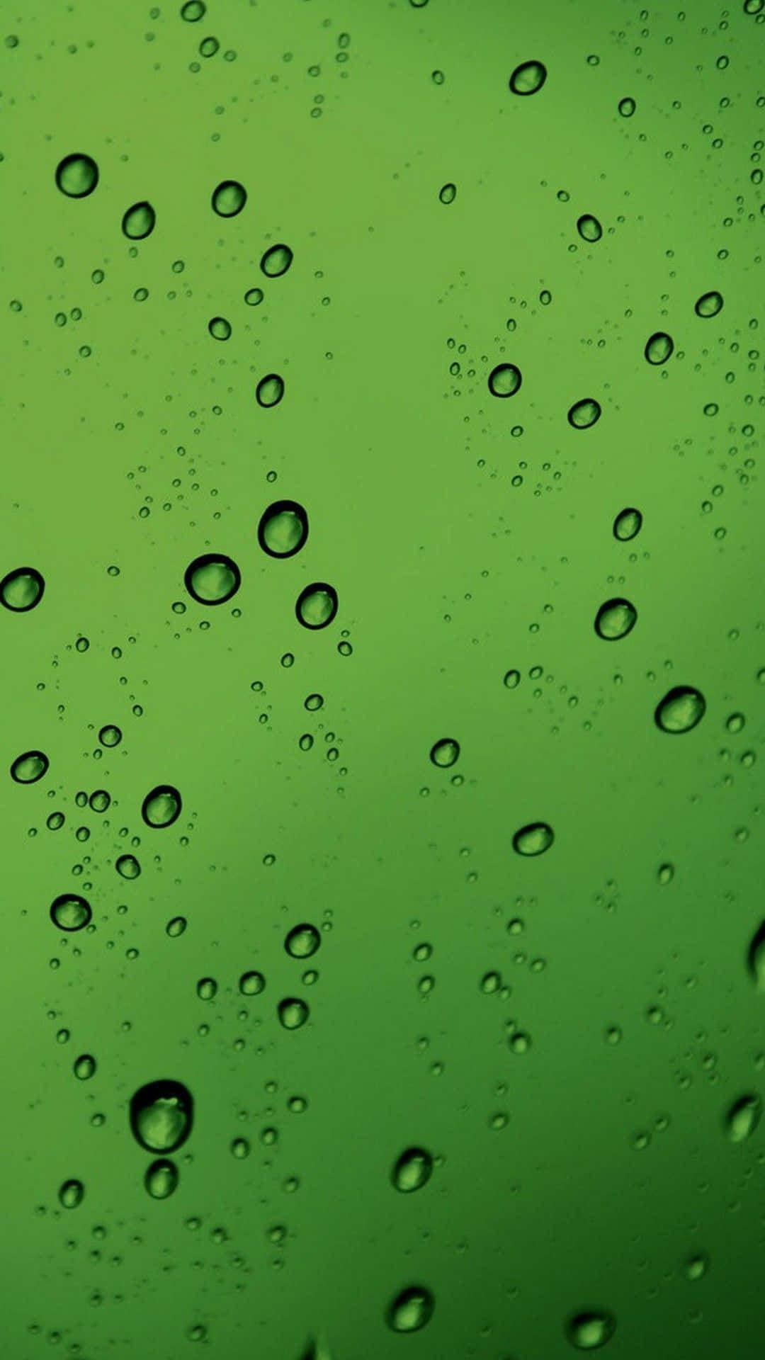Green Phone 桌布 壁紙 — 雨滴在充滿活力的綠色表面上閃閃發光的特寫，營造出寧靜清新的氛圍。