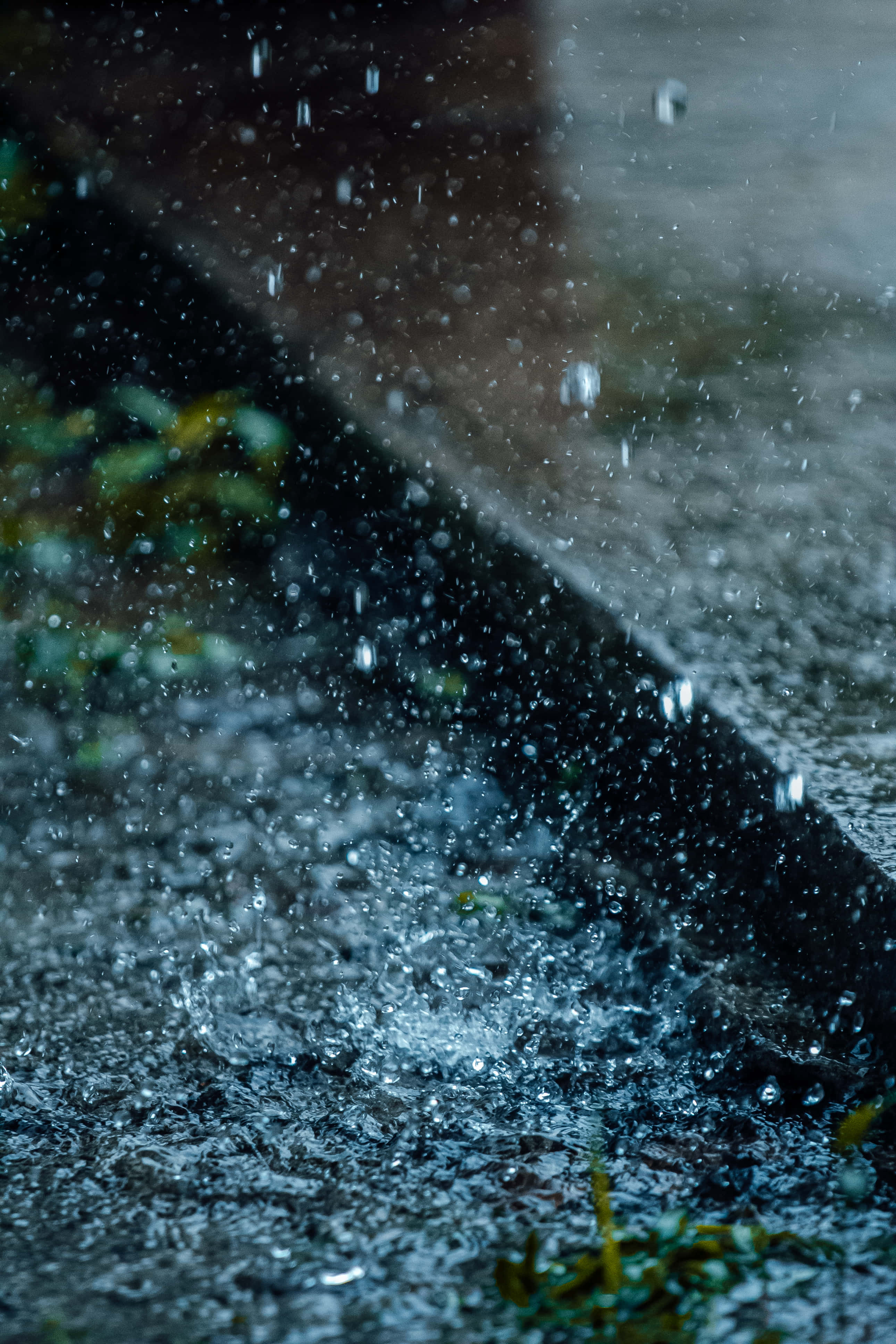 Rain Desktop 桌布 壁紙 — 雨滴在昏暗的暮光下戲劇性地濺在濕漉漉的人行道上。