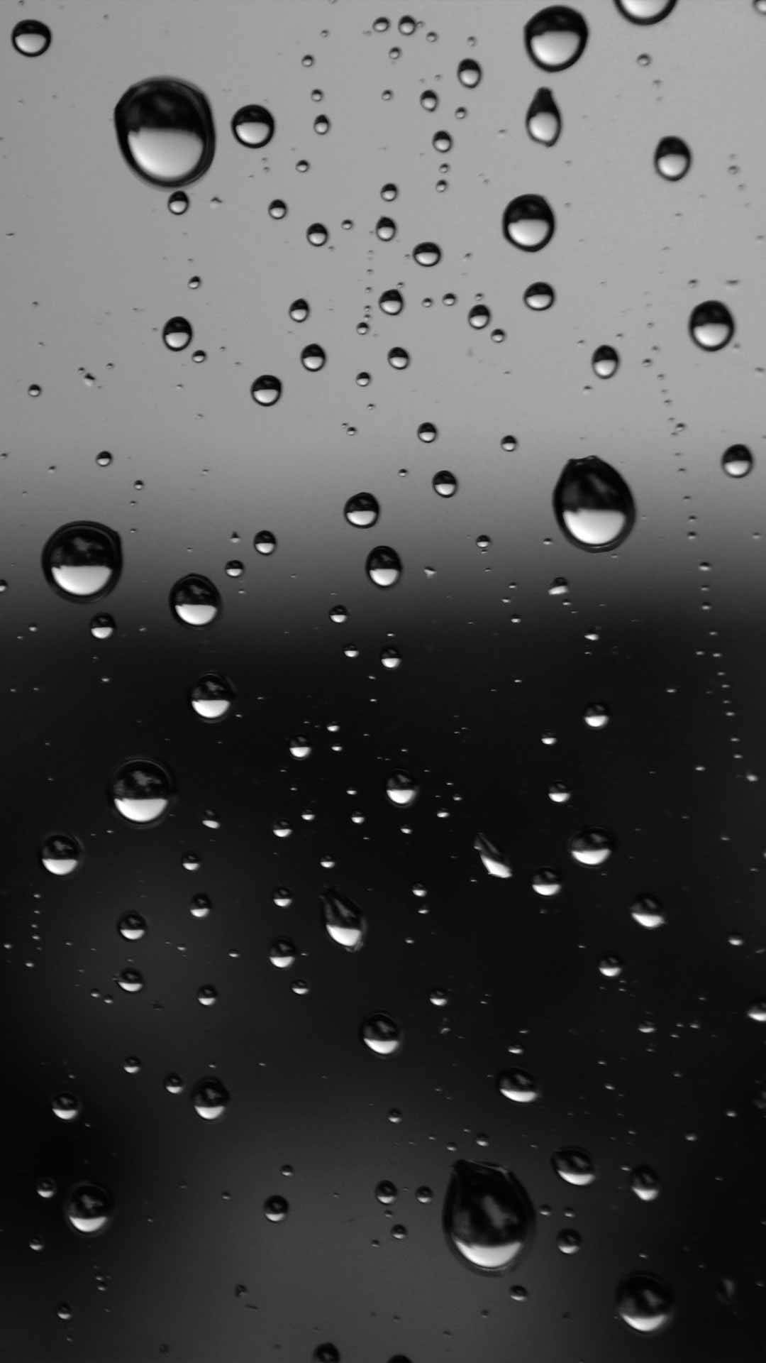 Dark Theme 桌布 壁紙 — 雨滴在深色玻璃表面上閃爍，營造出憂鬱的單色抽象圖案。