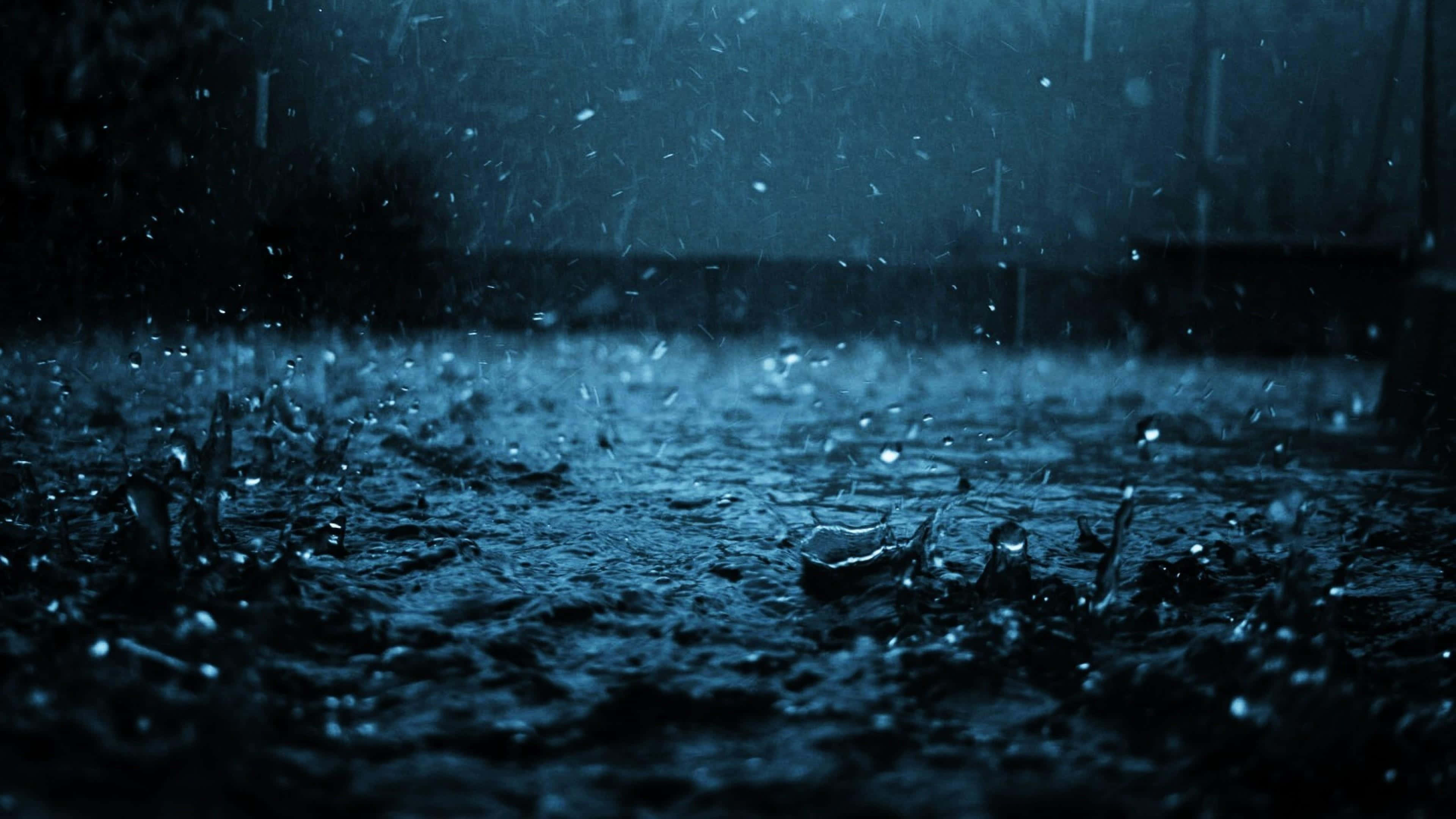 Rainy 桌布 壁紙 — 雨滴在黑暗潮濕的表面上戲劇性地飛濺，在憂鬱的藍色夜空下。