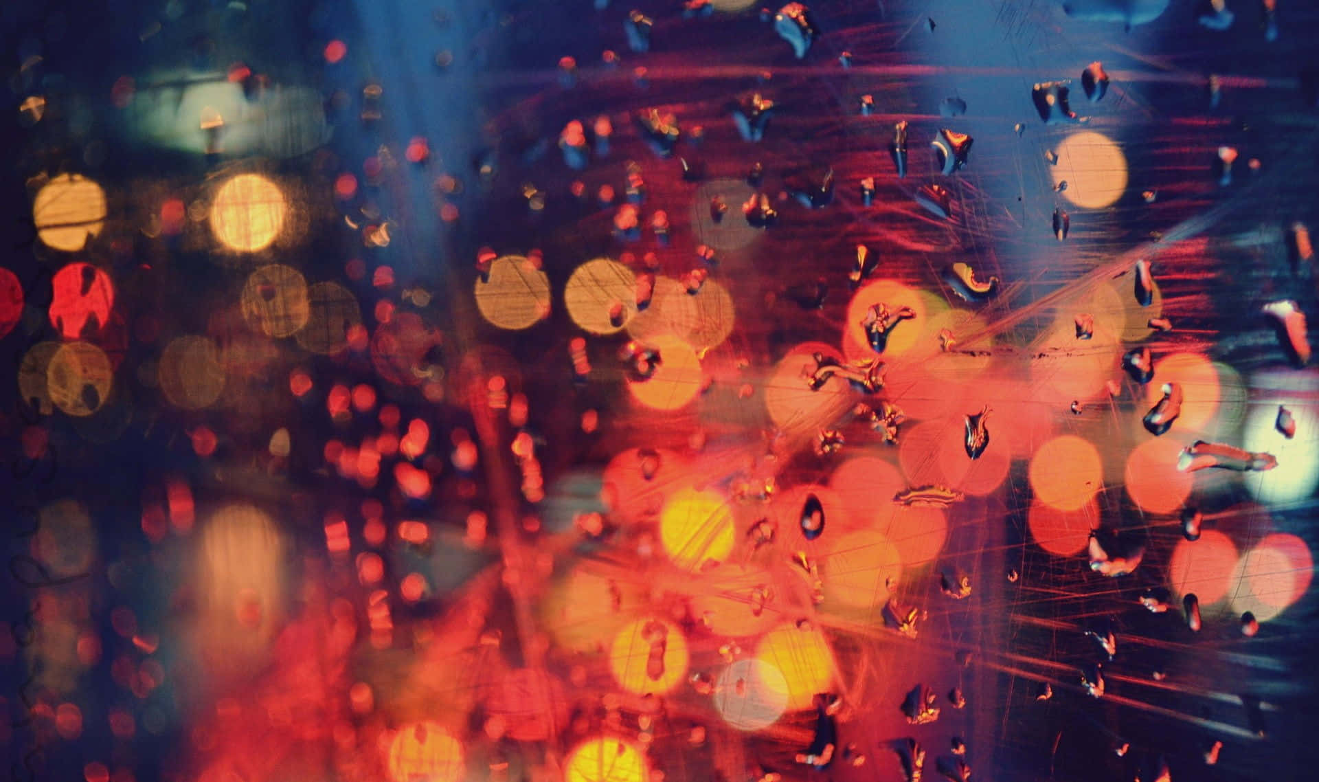 lights 桌布 壁紙 — 雨滴將充滿活力的城市燈光模糊成夜間濕窗上發光的散景條紋。