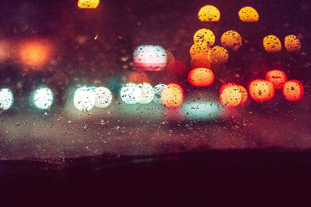 Raining 桌布 壁紙 — 雨滴將充滿活力的城市燈光模糊成發光球體，在夜間的車窗上。
