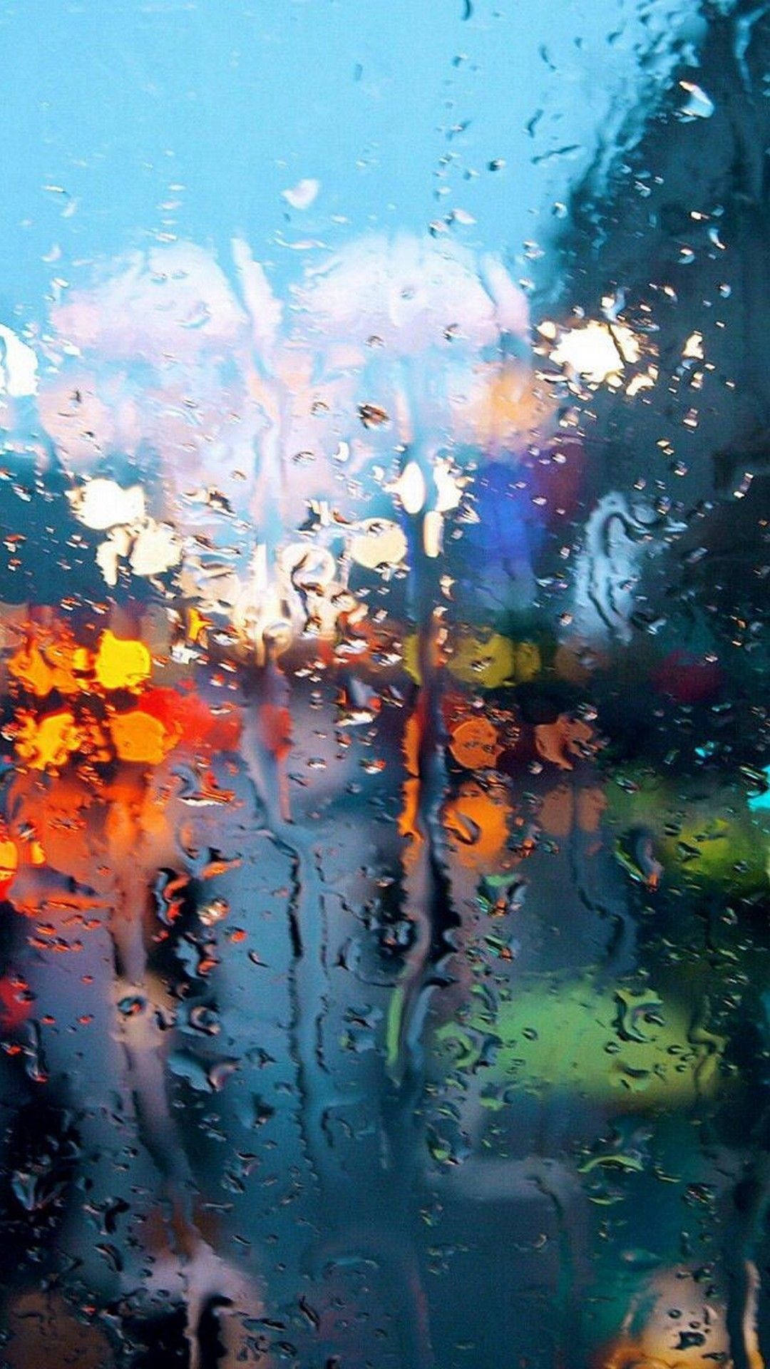 Rain 4K 桌布 壁紙 — 雨滴將夜間濕窗上充滿活力的城市燈光模糊成橙色、藍色和綠色的條紋。