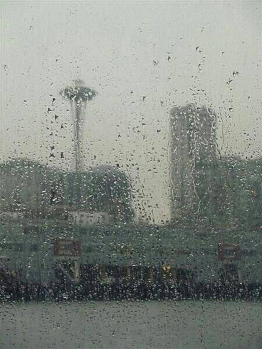 Rainy Day 桌布 壁紙 — 雨滴模糊了在灰濛濛的日子裡透過濕窗戶看到的西雅圖太空針塔和城市天際線的景色。
