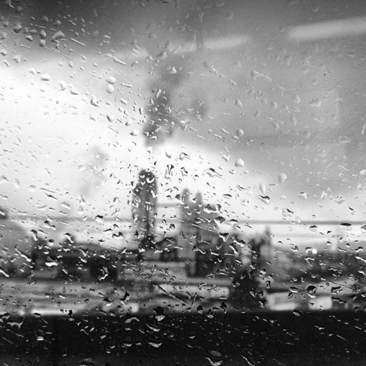 Rainy Day 桌布 壁紙 — 雨滴模糊了工業煙囪在灰色天空下排放煙霧的單色景象。