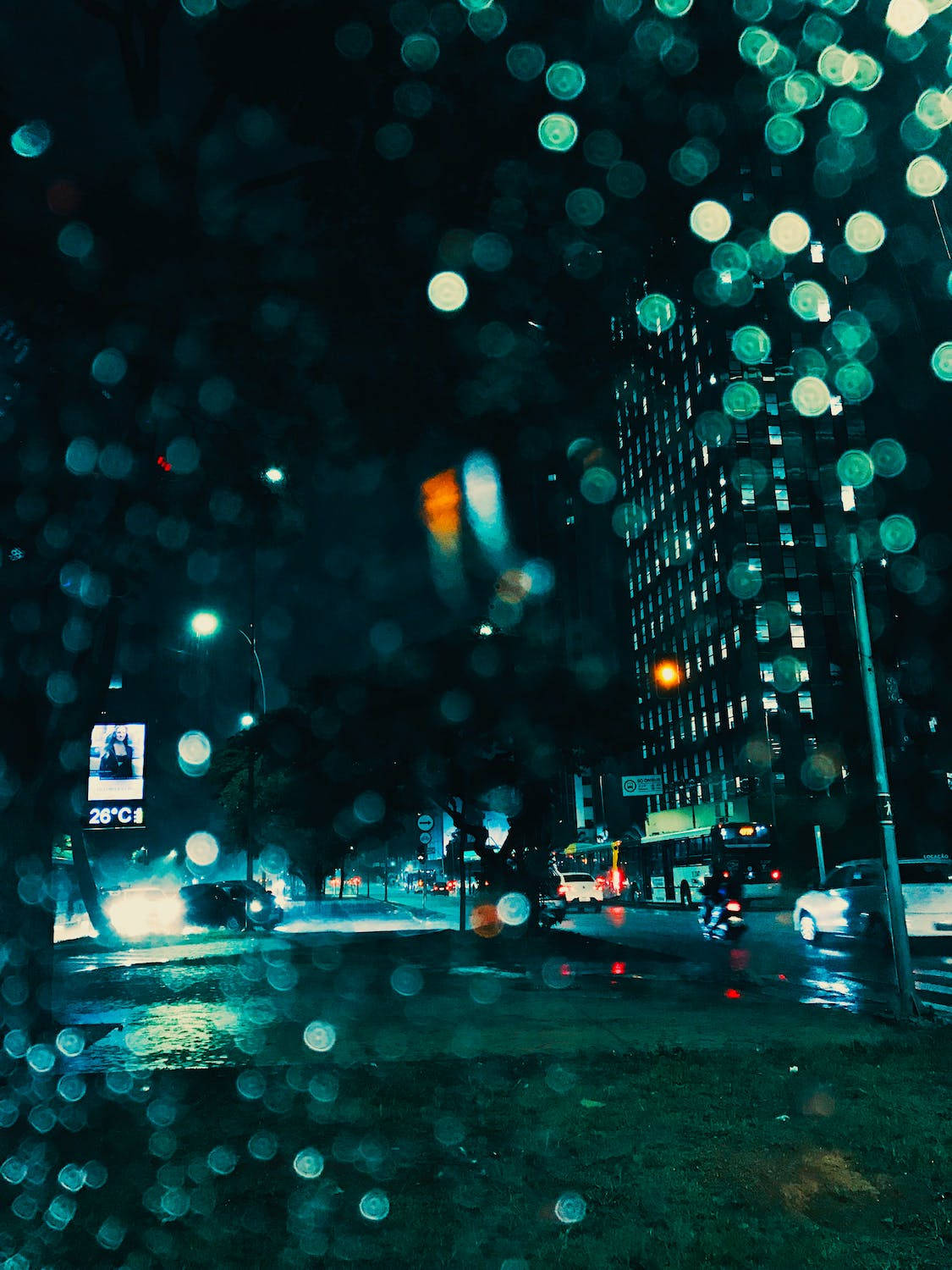 夜景城市 桌布 壁紙 — 雨滴模糊了從車內看到的濕漉漉的夜街上霓虹燈光。