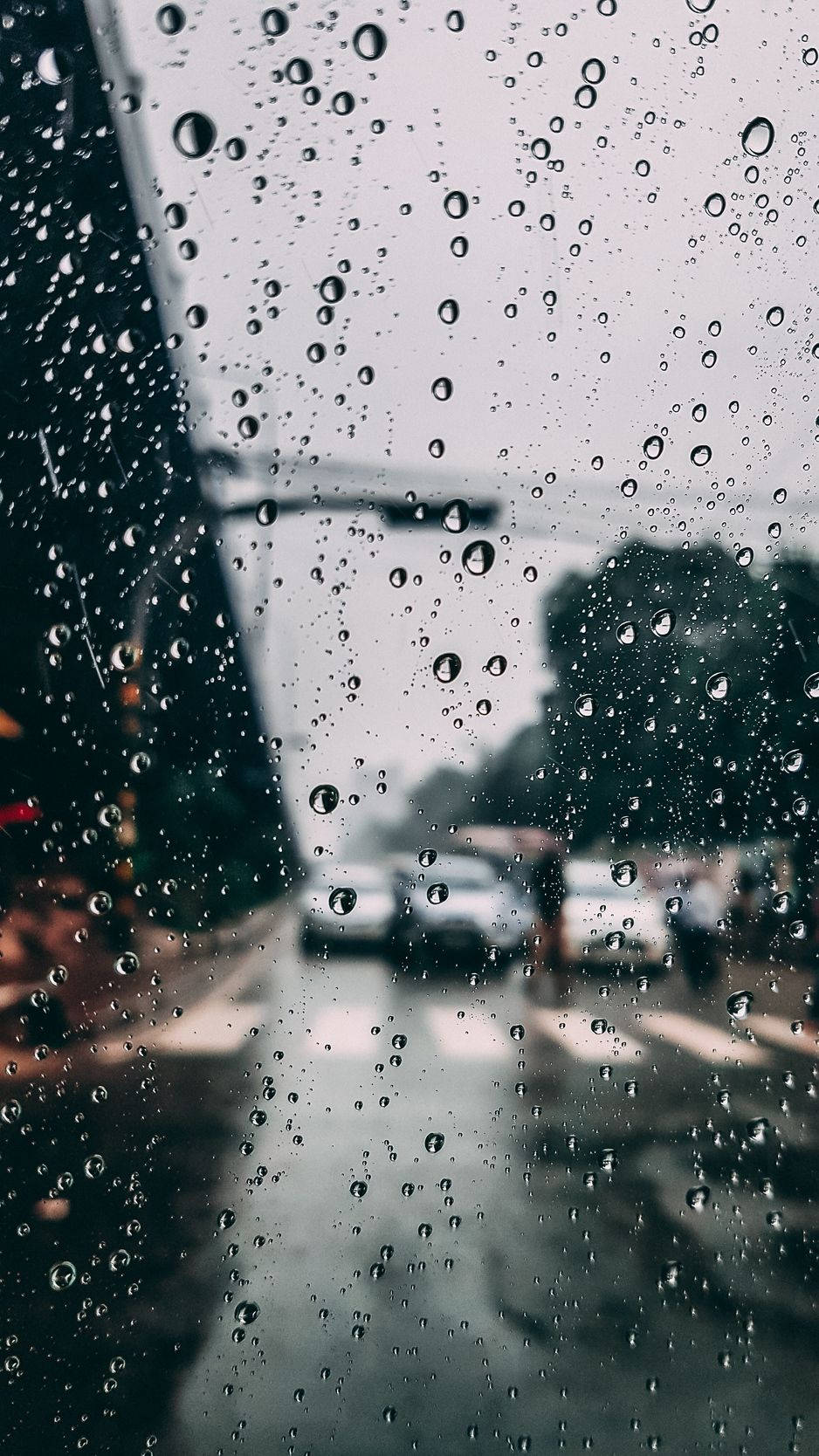 桌布 壁紙 — 雨滴模糊了灰色日子裡透過車窗看到的濕漉漉的城市街道。