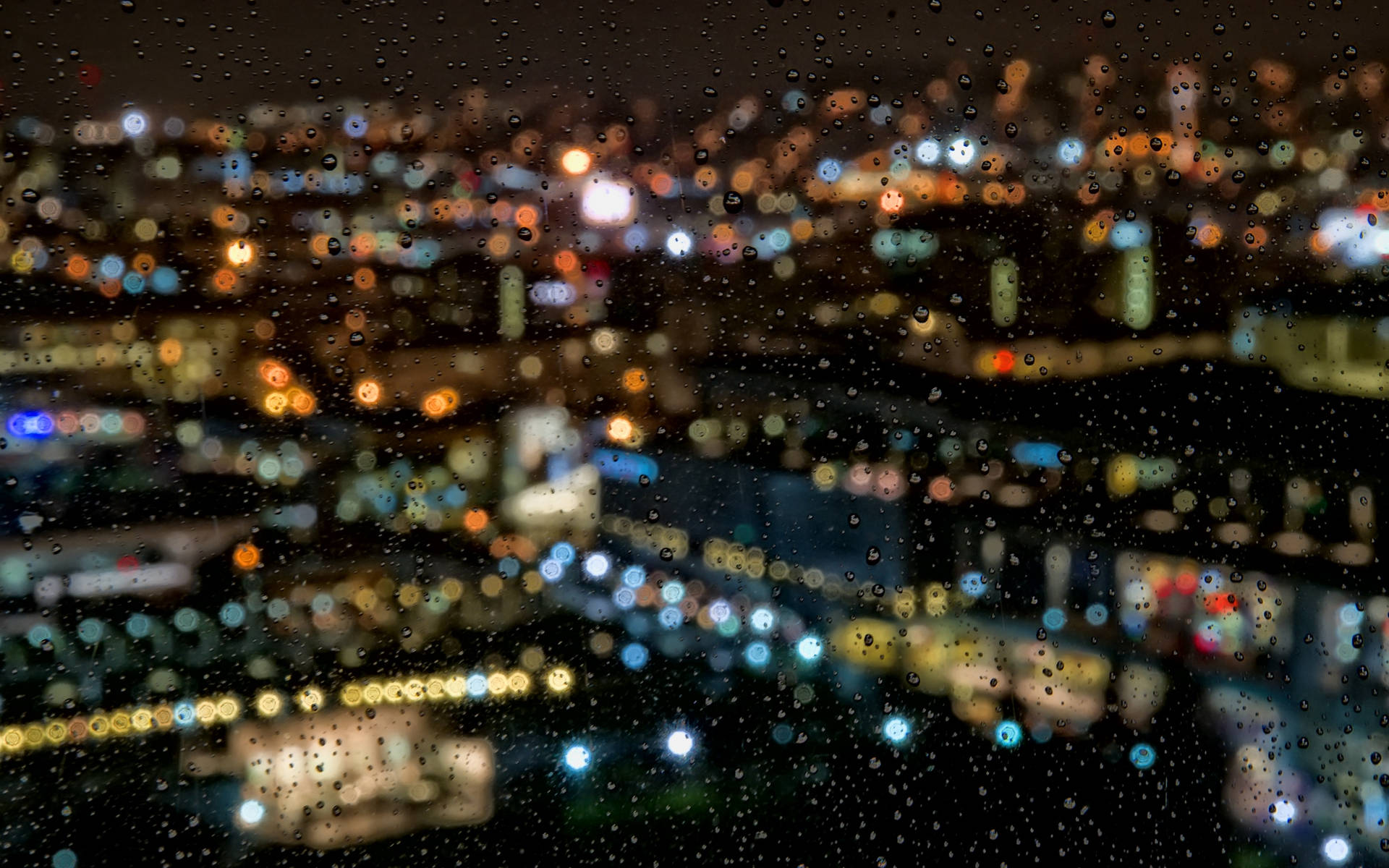 窗戶上的雨滴，俯瞰夜晚閃爍的城市。