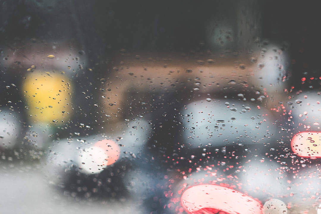 Raining 桌布 壁紙 — 雨滴模糊了透過車窗看到的景色，紅色和黃色的尾燈條紋在潮濕的黑暗中閃爍。