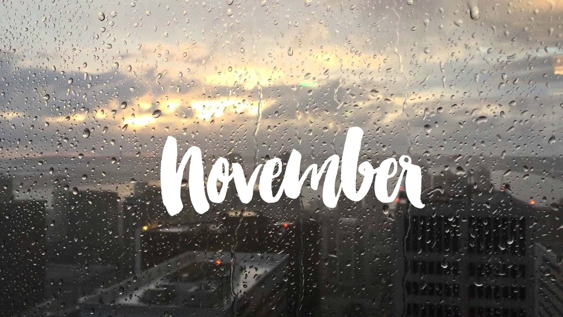 十一月 桌布 壁紙 — 雨滴沿窗戶流下，多雲的十一月夕陽以柔和的金光照耀城市景觀。