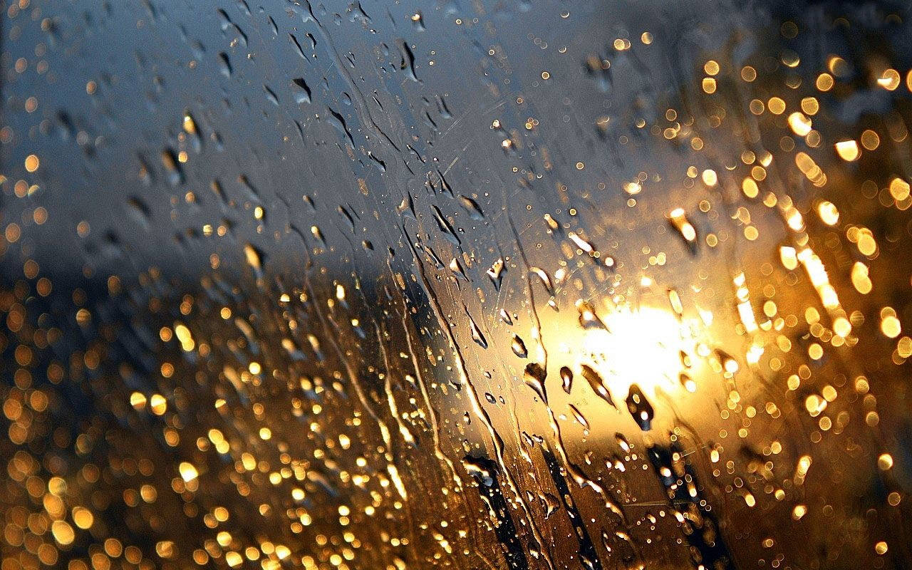 Rainy Day 桌布 壁紙 — 雨滴沿窗戶流下，金色的陽光在漸暗的天空中形成散景亮點。
