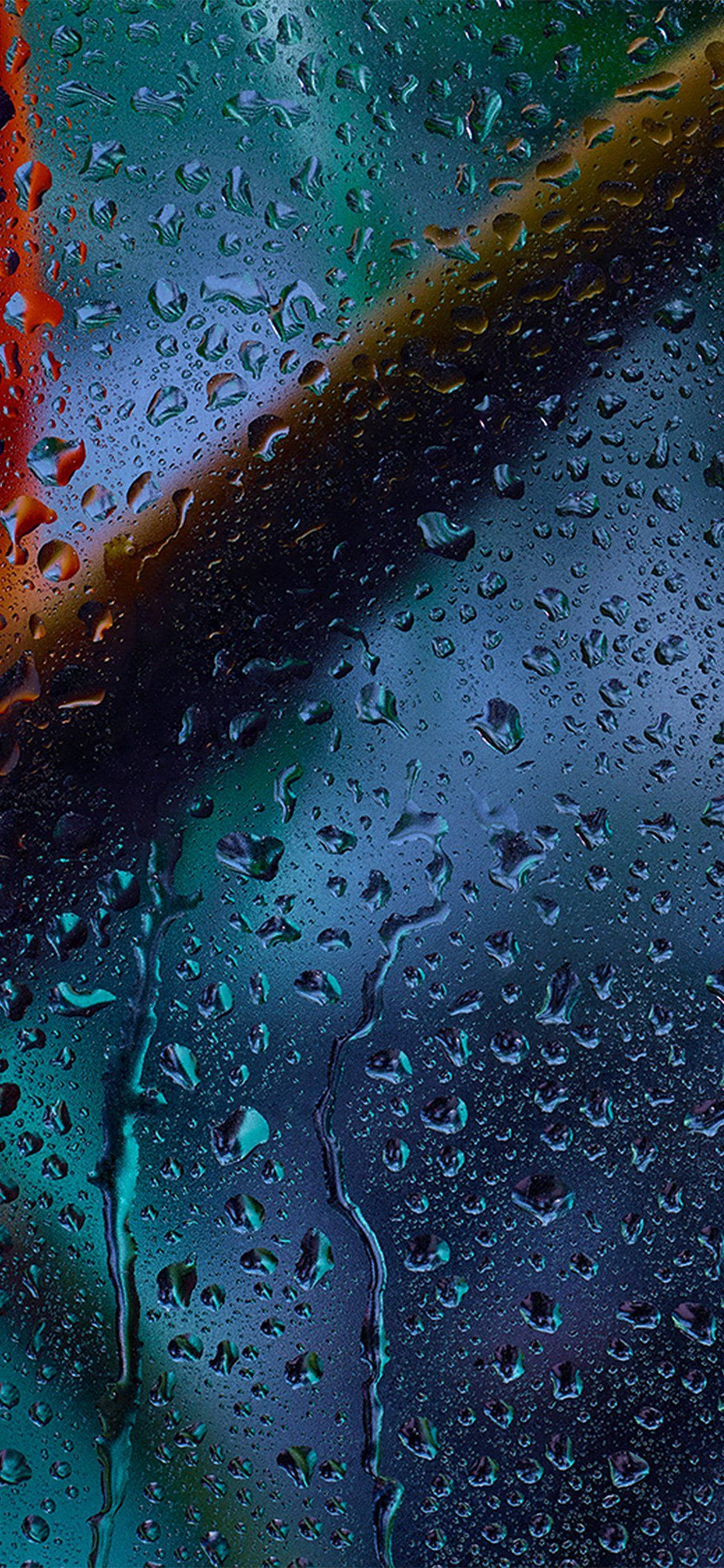Raindrops 桌布 壁紙 — 雨滴沿窗戶流下，顯露出深藍色和火紅色的模糊霓虹燈光。
