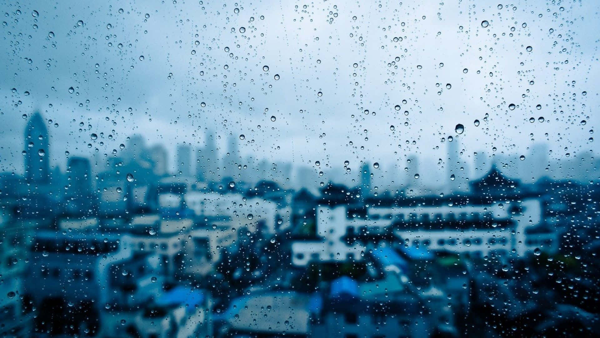 動漫 桌布 壁紙 — 雨滴沿窗戶流下，顯露出陰天下一片模糊的藍灰色城市景觀。