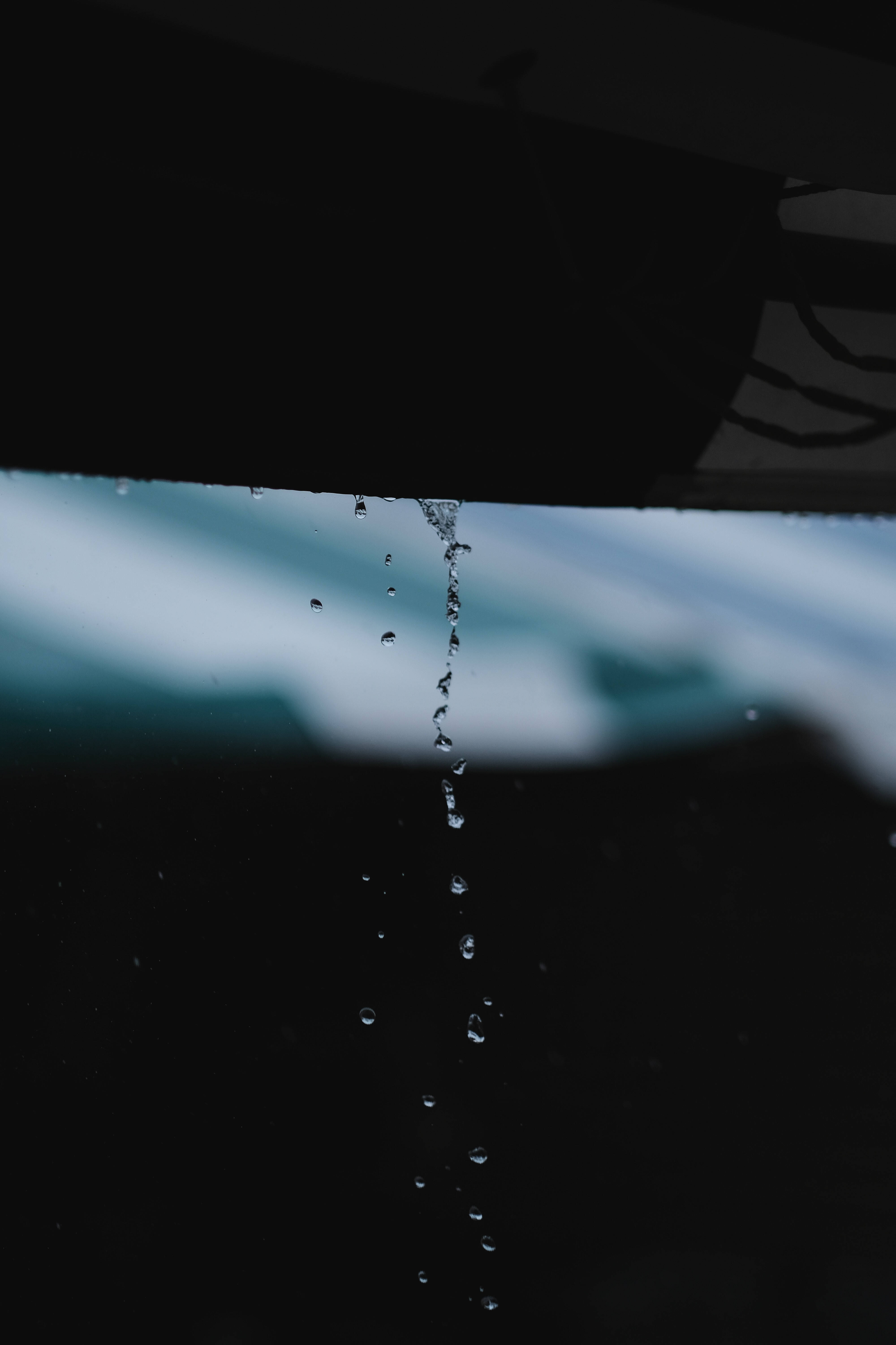 下雨 桌布 壁紙 — 雨滴沿著深色車窗流下，背景是模糊的藍天。