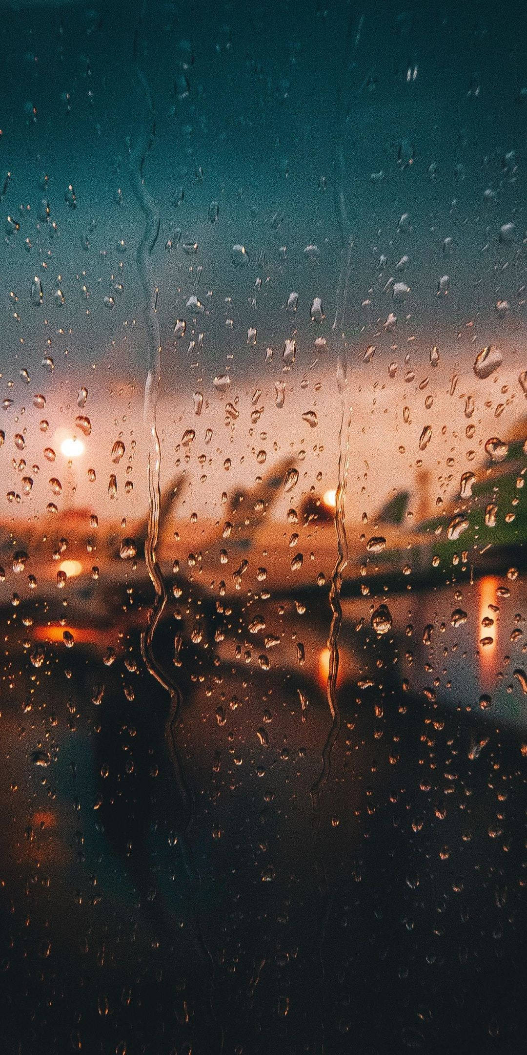 Airport 桌布 壁紙 — 雨滴沿著窗戶流下，模糊的城市燈光在暮色天空中溫暖地閃耀。