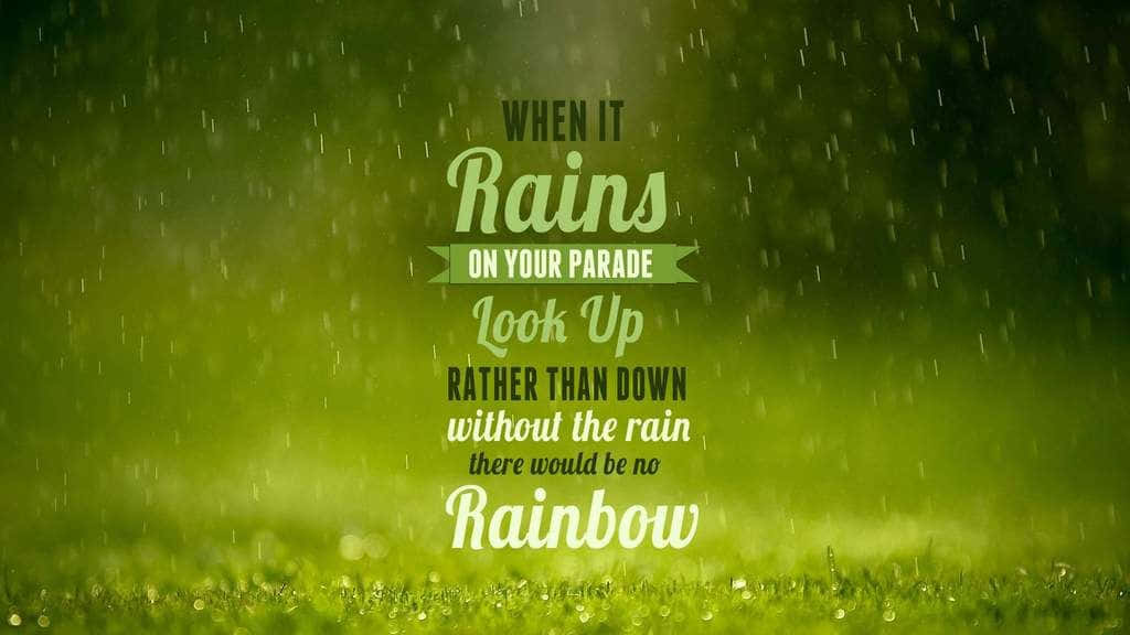 桌布 壁紙 — 雨滴落在充滿活力的綠草上，勵志文字鼓勵在風暴後抬頭尋找彩虹。