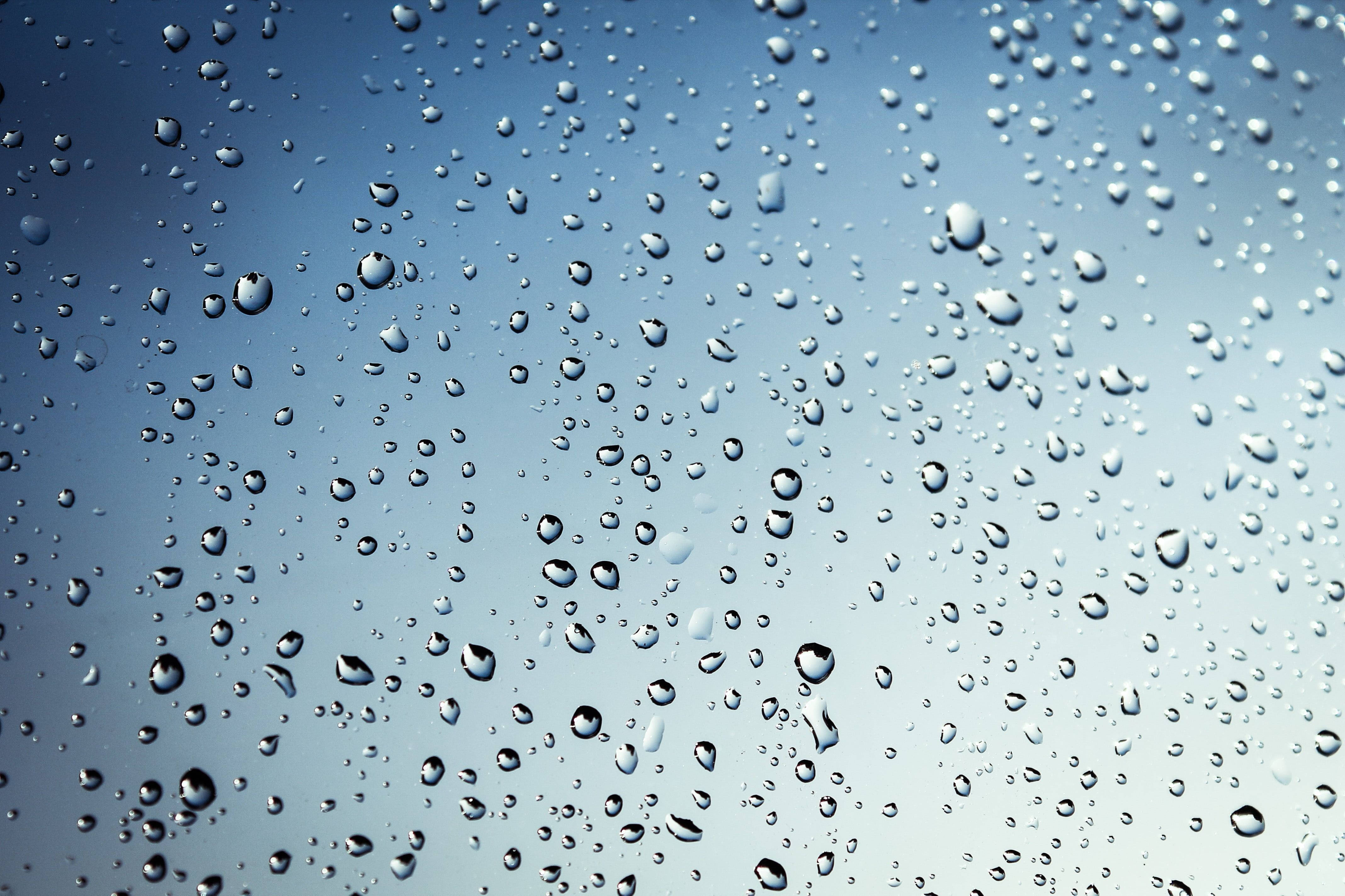 Rainy Day 桌布 壁紙 — 雨滴附著在玻璃表面，反射出柔和的藍天，帶有細微的漸層和散落的水滴。