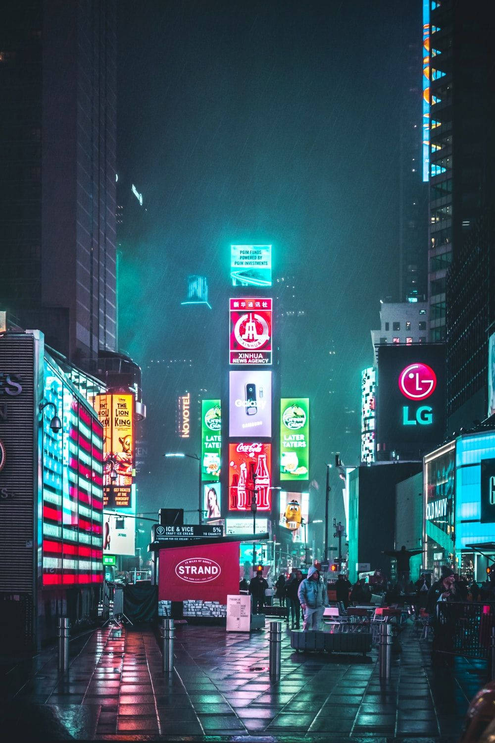 霓虹城市動態圖 桌布 壁紙 — 雨濕的夜晚城市街道，被鮮豔的霓虹招牌照亮，反射在濕漉漉的路面上。