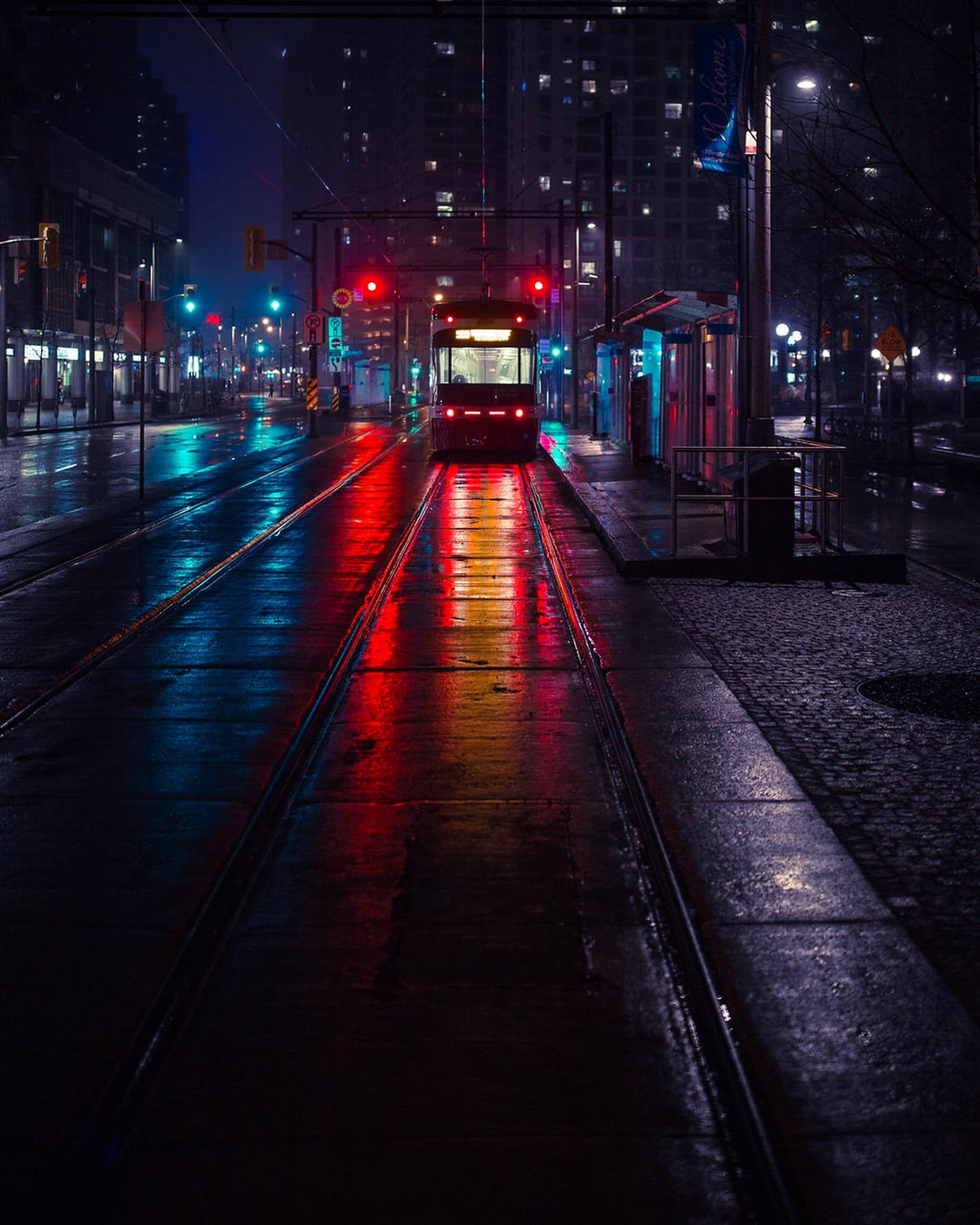 一輛電車在濕漉漉的夜晚城市街道上行駛，反射著紅色和藍色的霓虹燈光。 — 黑暗城市 壁紙