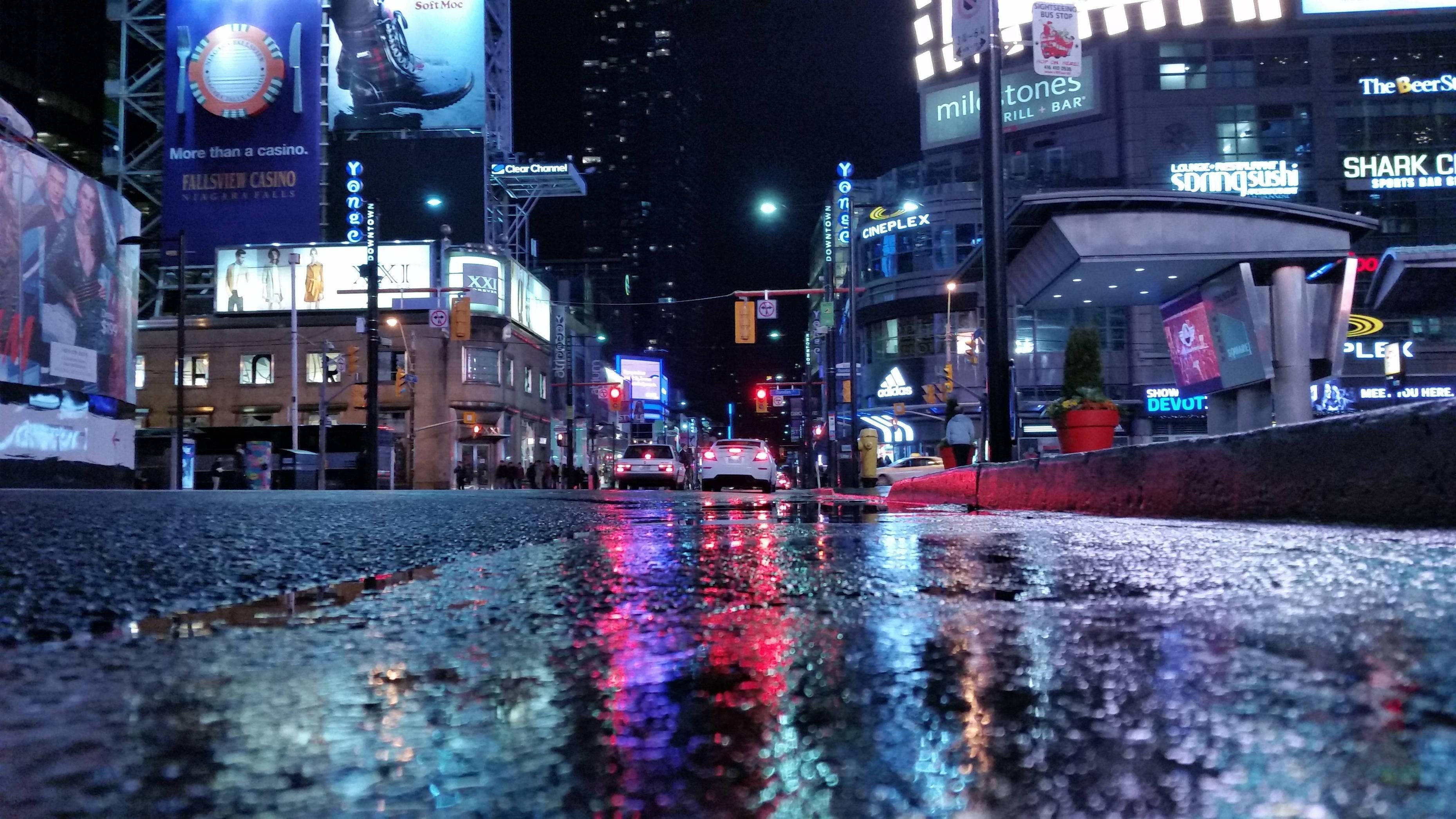 Ontario 桌布 壁紙 — 雨濕的夜晚城市街道反射著高聳建築物和發光廣告牌的霓虹招牌。