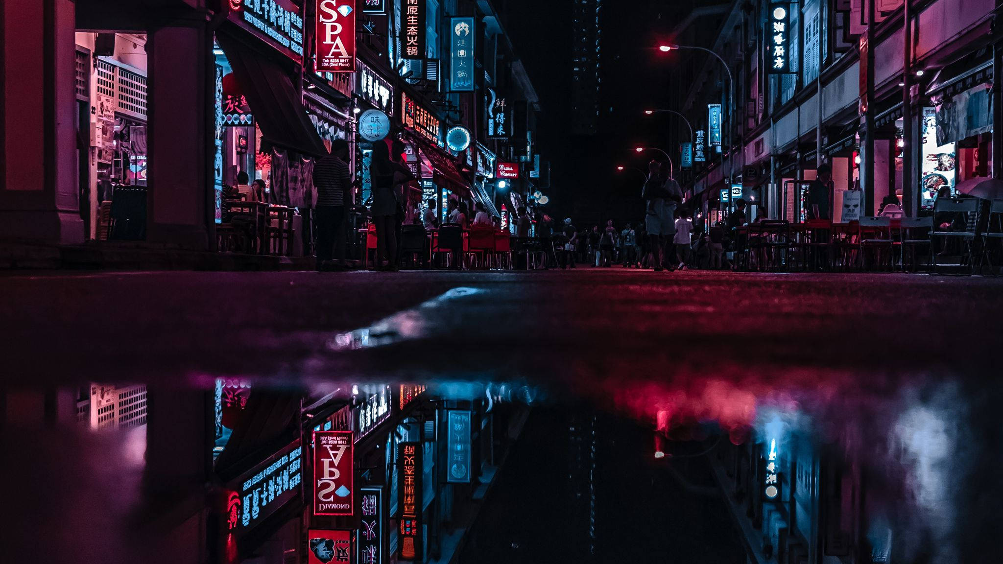 霓虹城市動態圖 桌布 壁紙 — 雨濕的夜間城市街道反射出鮮豔粉紅和藍色的霓虹燈招牌。