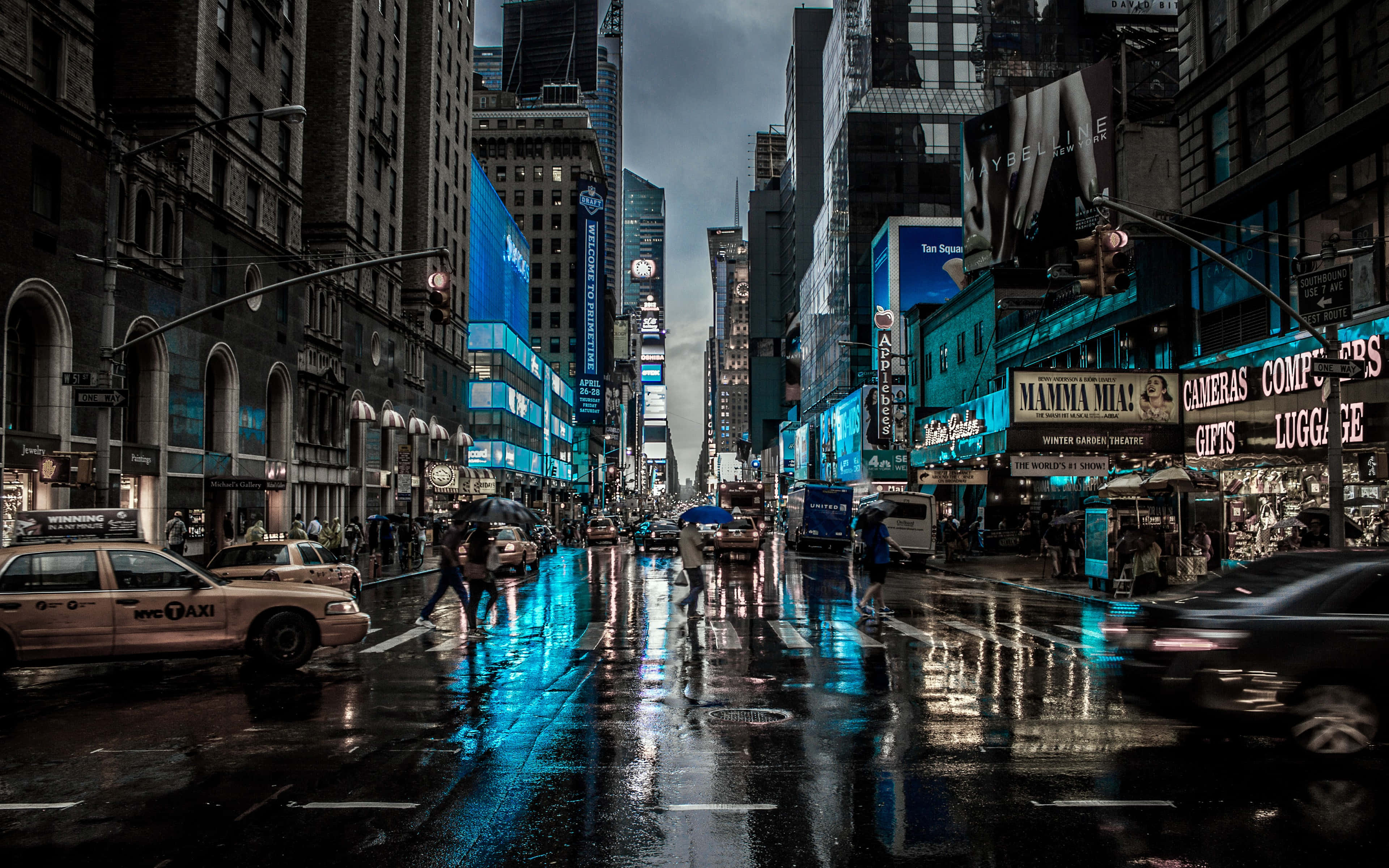 City Desktop 桌布 壁紙 — 雨濕的時代廣場夜晚，在黑暗的天空下反射霓虹燈牌和移動的計程車。