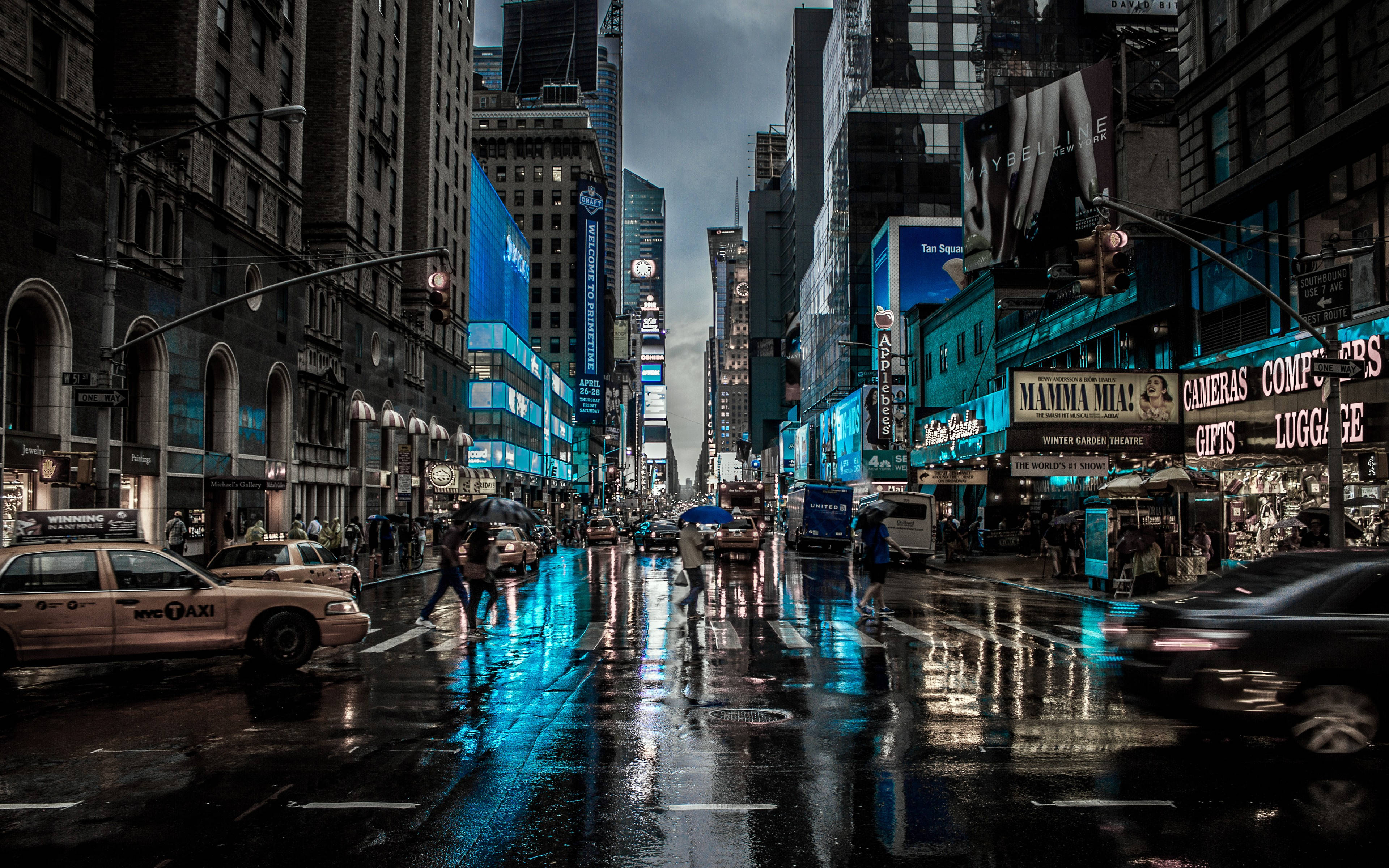 New York City Desktop 桌布 壁紙 — 雨濕的時代廣場夜晚，在黑暗的天空下反射霓虹燈牌和移動的計程車。