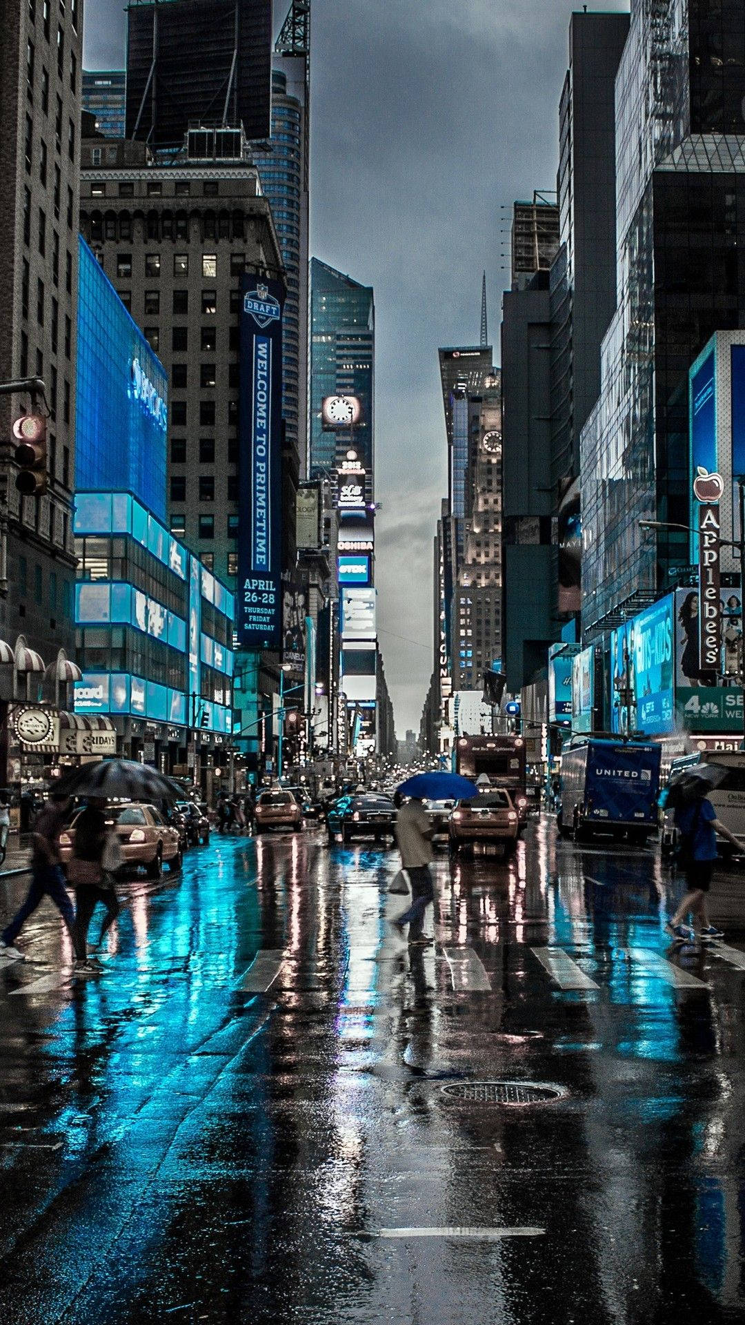 New York 桌布 壁紙 — 雨濕的時代廣場夜晚，霓虹廣告牌和城市燈光反射在濕漉漉的人行道上，行人匆匆撐傘。