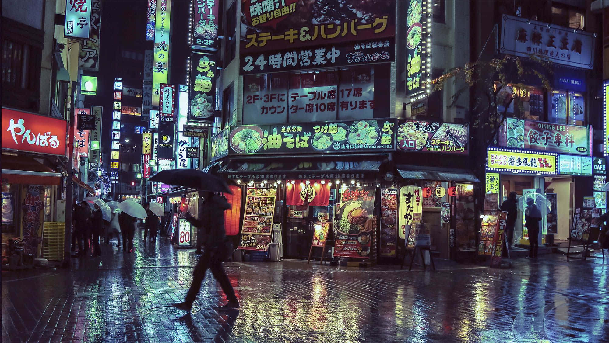 桌布 壁紙 — 雨濕的東京夜晚街道，霓虹燈和雨傘閃爍，行人匆匆走過明亮的店舖櫥窗。