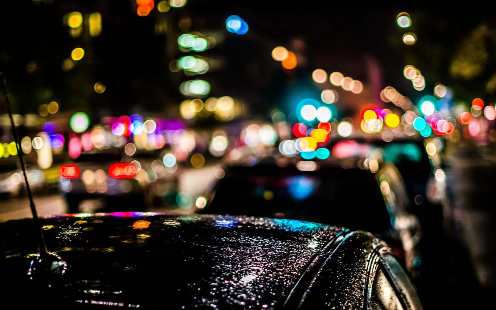 City Lights 桌布 壁紙 — 雨濕的汽車引擎蓋反射出繁華城市街道夜晚的鮮豔散景燈光。