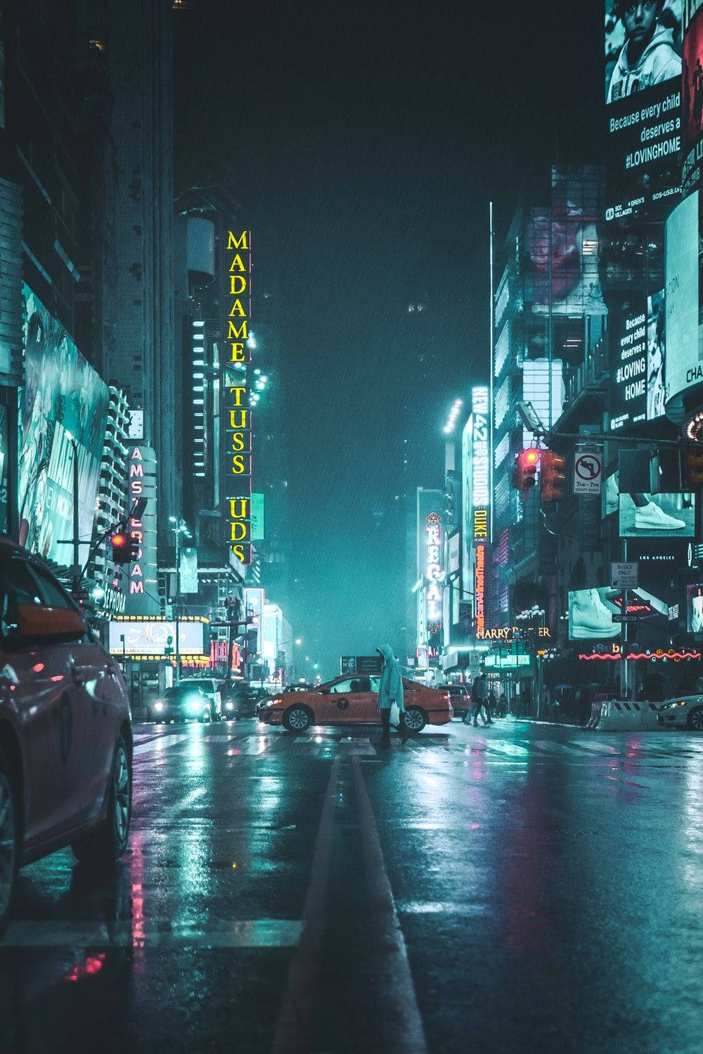 霓虹城市動態圖 桌布 壁紙 — 雨濕的紐約市街道在夜晚閃耀，霓虹燈牌在濕漉漉的人行道上反射，聳立的廣告牌下。