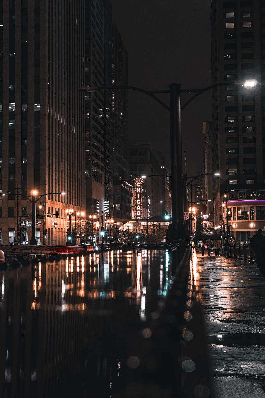 芝加哥 桌布 壁紙 — 雨濕的芝加哥夜晚街道，在陰鬱的城市場景中反射著霓虹燈和高聳的建築物。