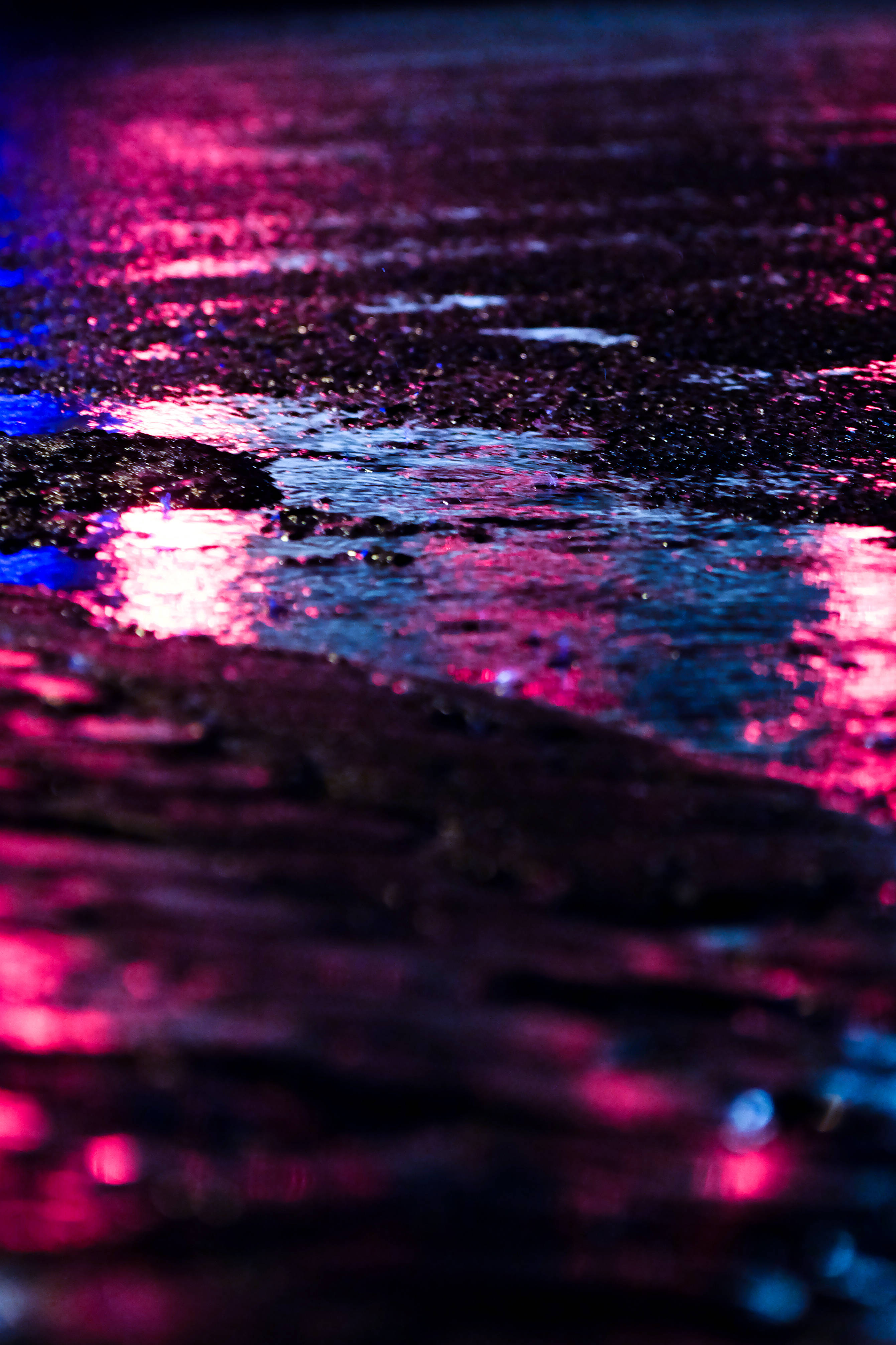 淡紫色 桌布 壁紙 — 雨濕的路面在夜晚閃爍著電光粉紅和藍色霓虹反射。