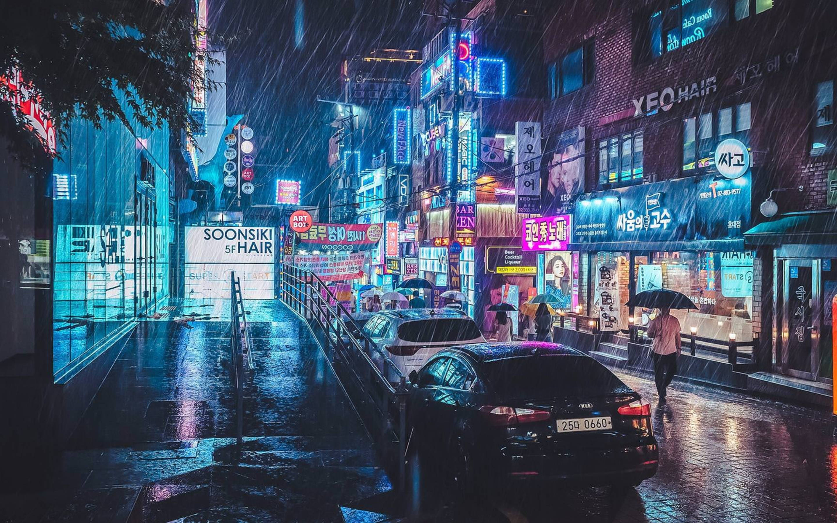 korean 桌布 壁紙 — 雨濕的霓虹燈街道夜景，發光的招牌在濕漉漉的人行道上反射，行人撐傘走過。