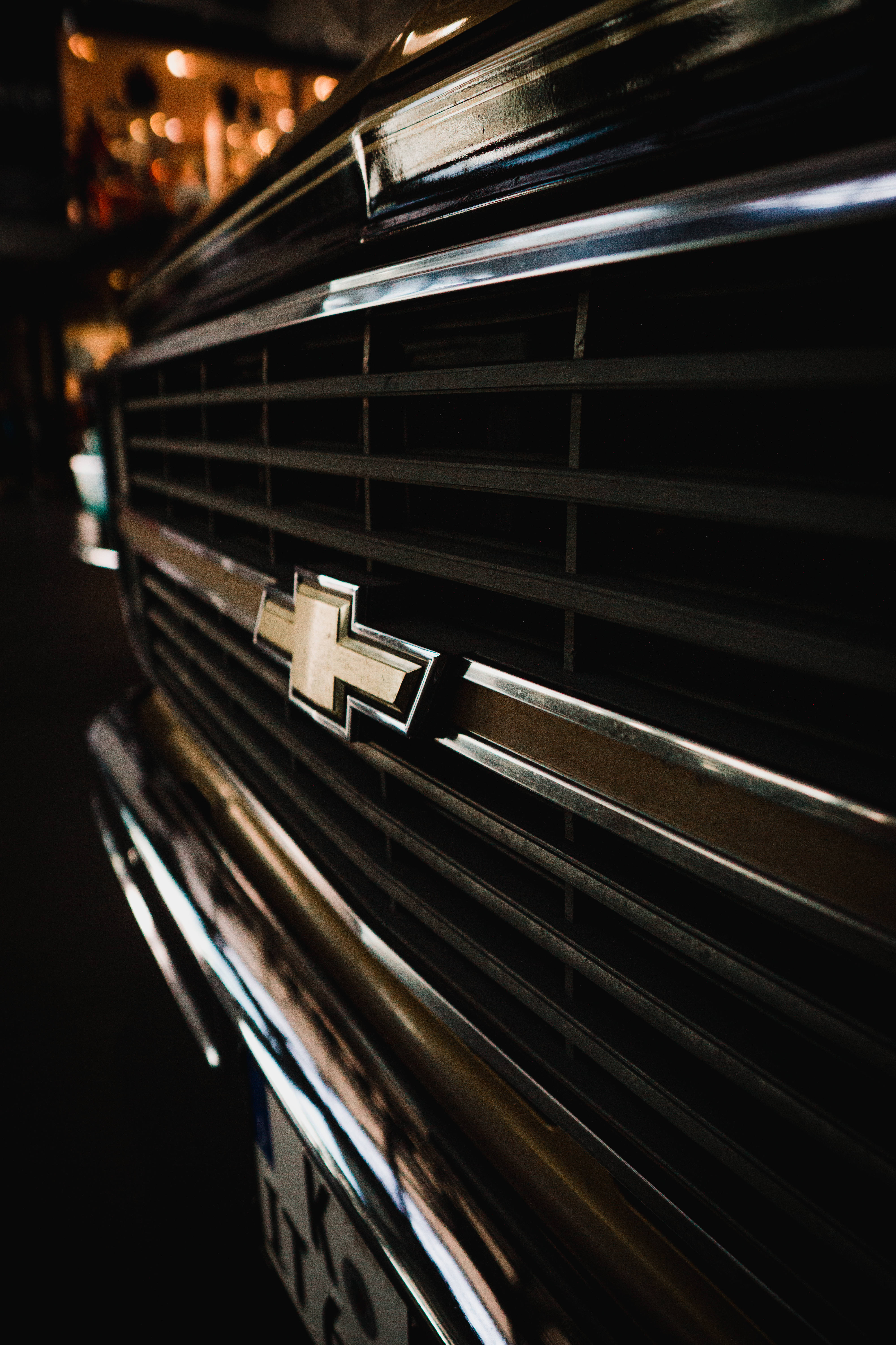 Chevrolet Logo 桌布 壁紙 — 雪佛蘭卡車格柵特寫，帶有鍍鉻裝飾和背景中發光的燈光。